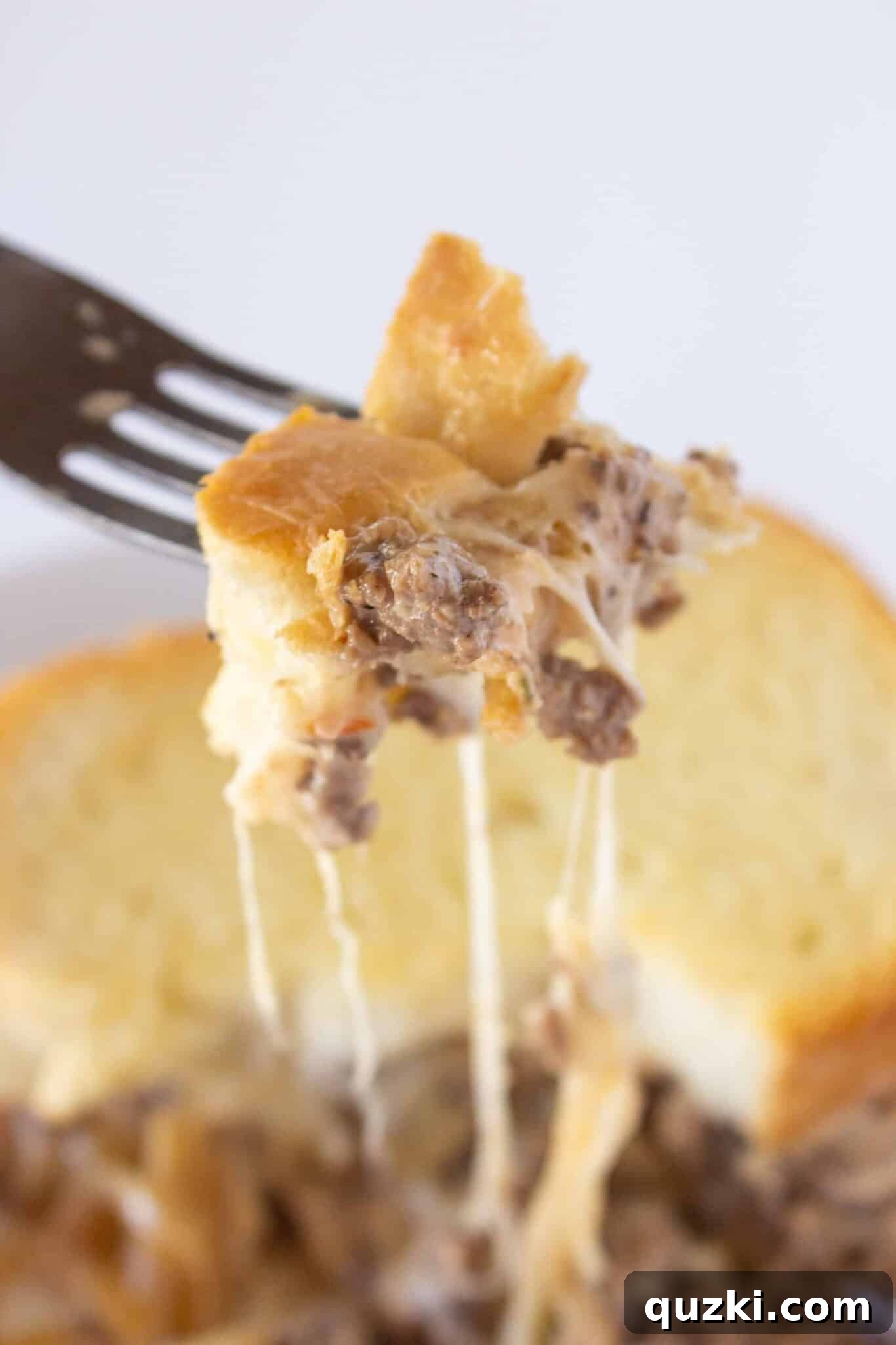 A delicious serving of Classic Patty Melt Casserole on a fork, ready to be enjoyed.