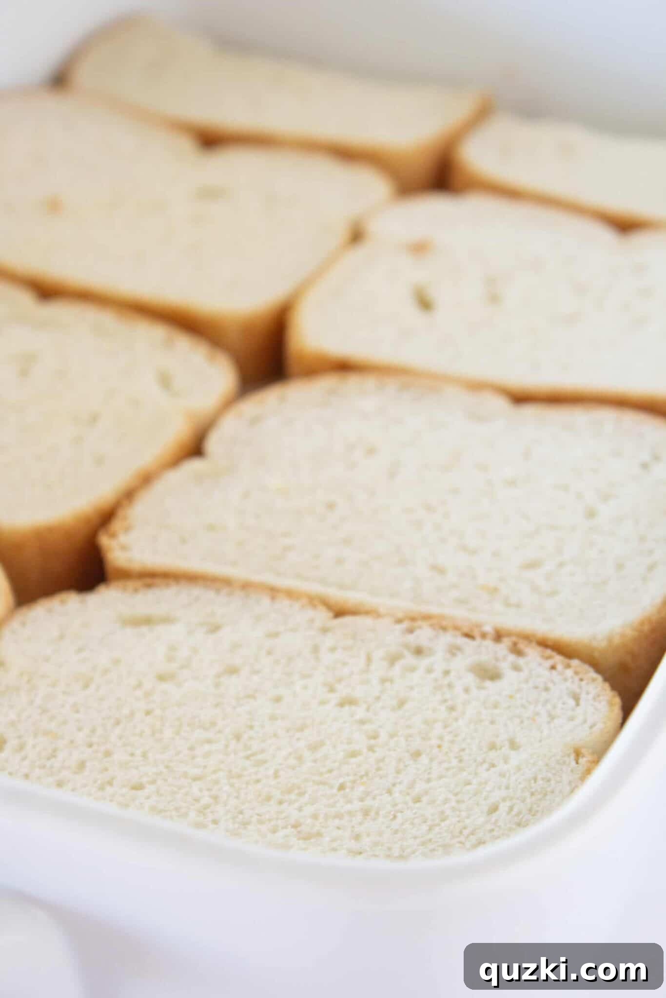 Preparing the bread for the casserole, buttered sides visible.