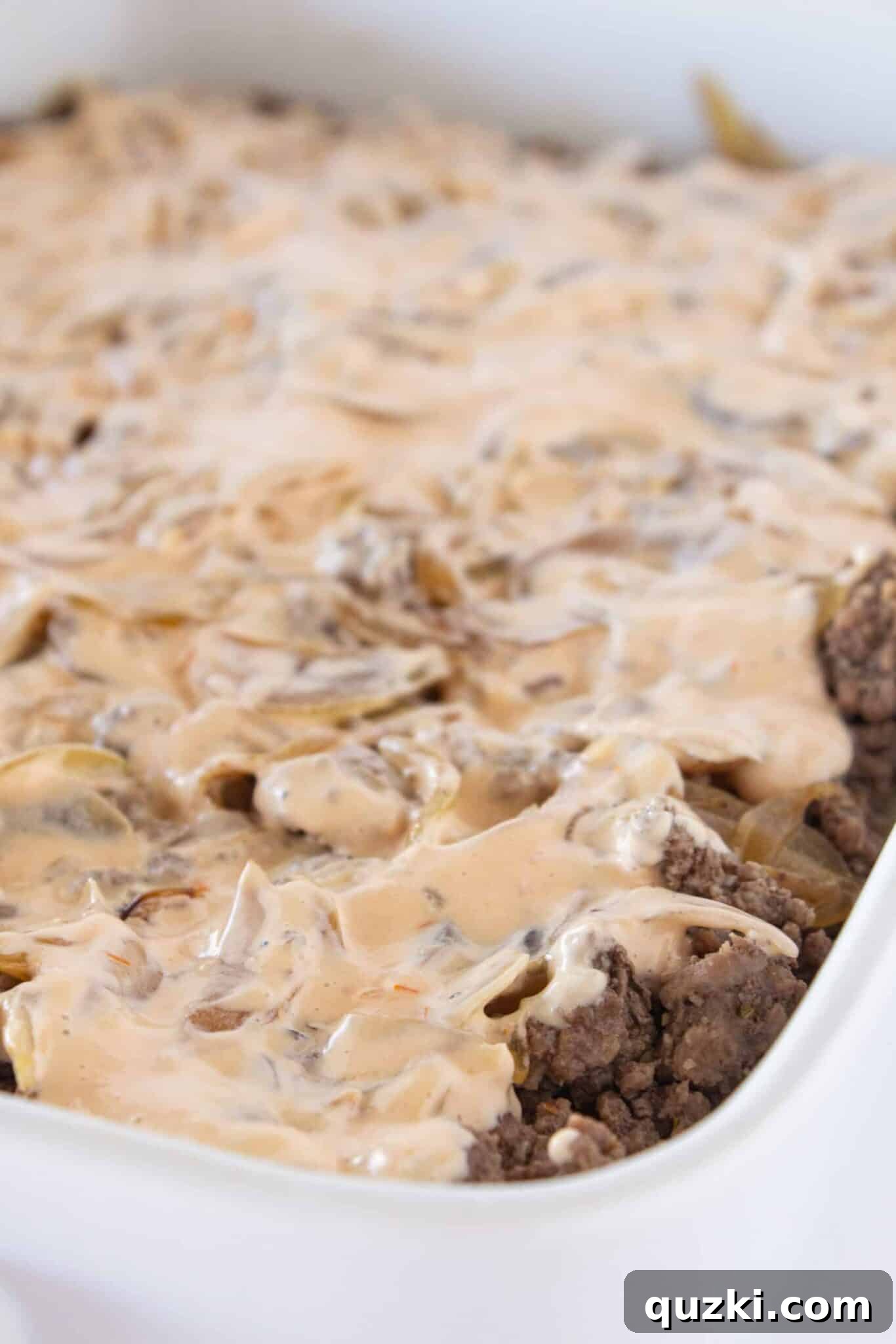 Adding sauteed onions and Thousand Island dressing to the casserole.
