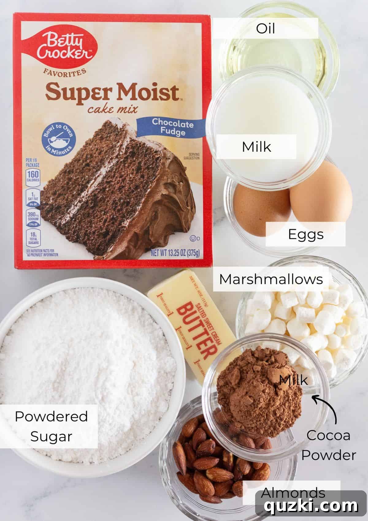 A vibrant flat lay of all the fresh ingredients needed to bake a batch of homemade Rocky Road Cookies from scratch, including a box of chocolate fudge cake mix, mini marshmallows, butter, cocoa powder, milk, and almonds.