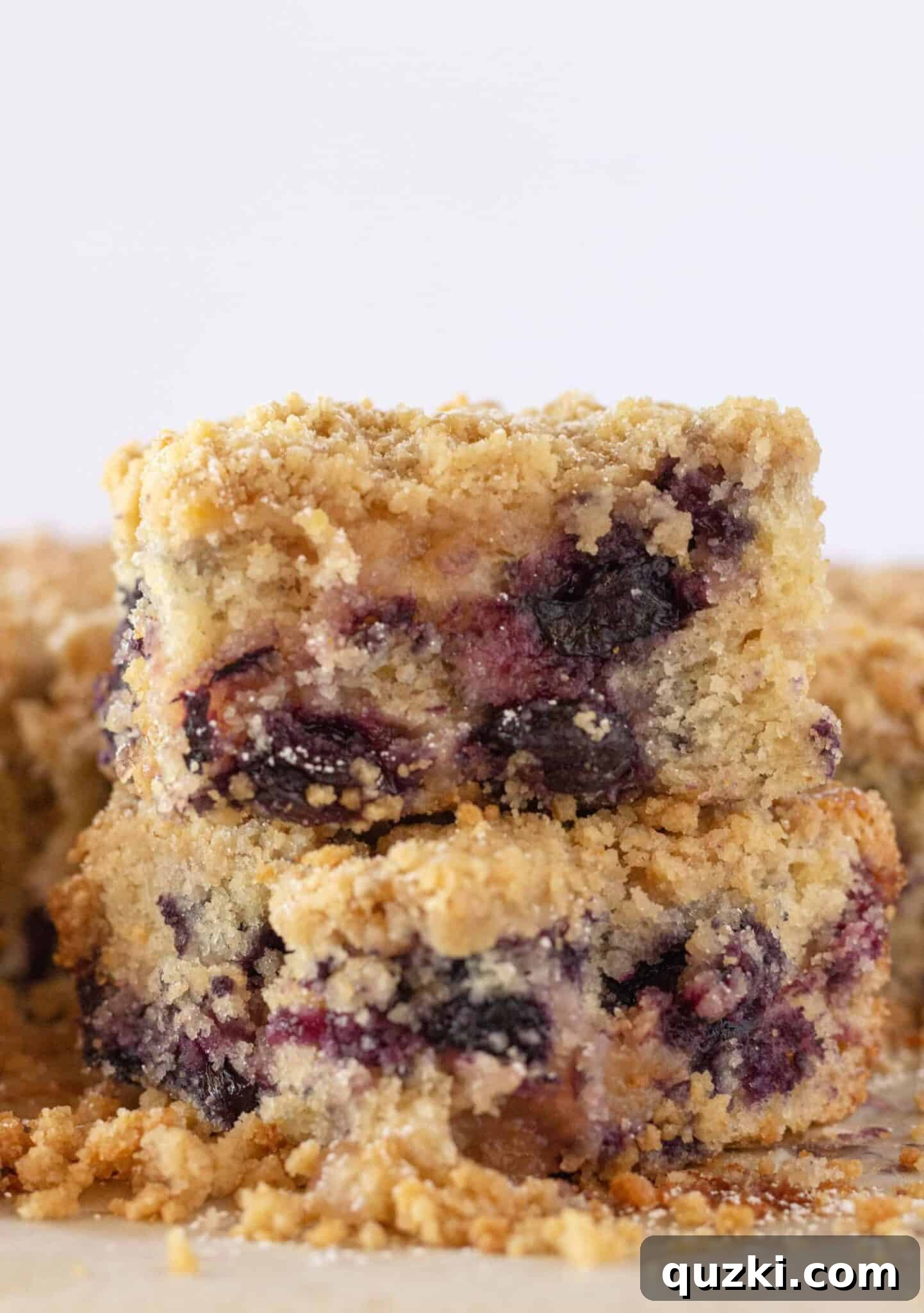 Effortless Lemon Blueberry Sour Cream Crumb Cake 14 Stacked squares of Easy Lemon Blueberry Crumb Cake, showcasing the tender cake, juicy blueberries, and crunchy topping.