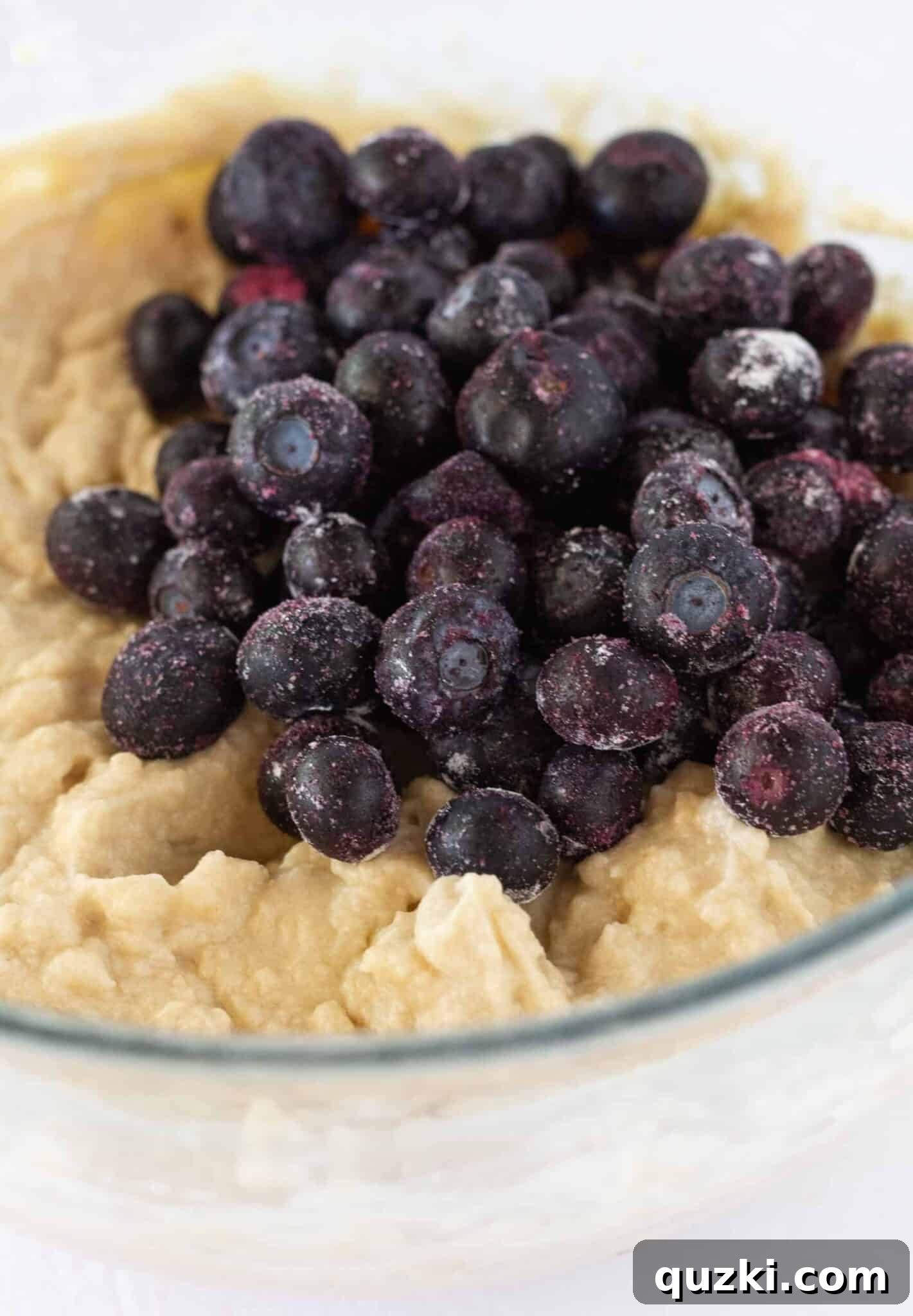 Effortless Lemon Blueberry Sour Cream Crumb Cake 7 The final stage of preparing the crumb cake batter, gently folding in fresh or frozen blueberries.