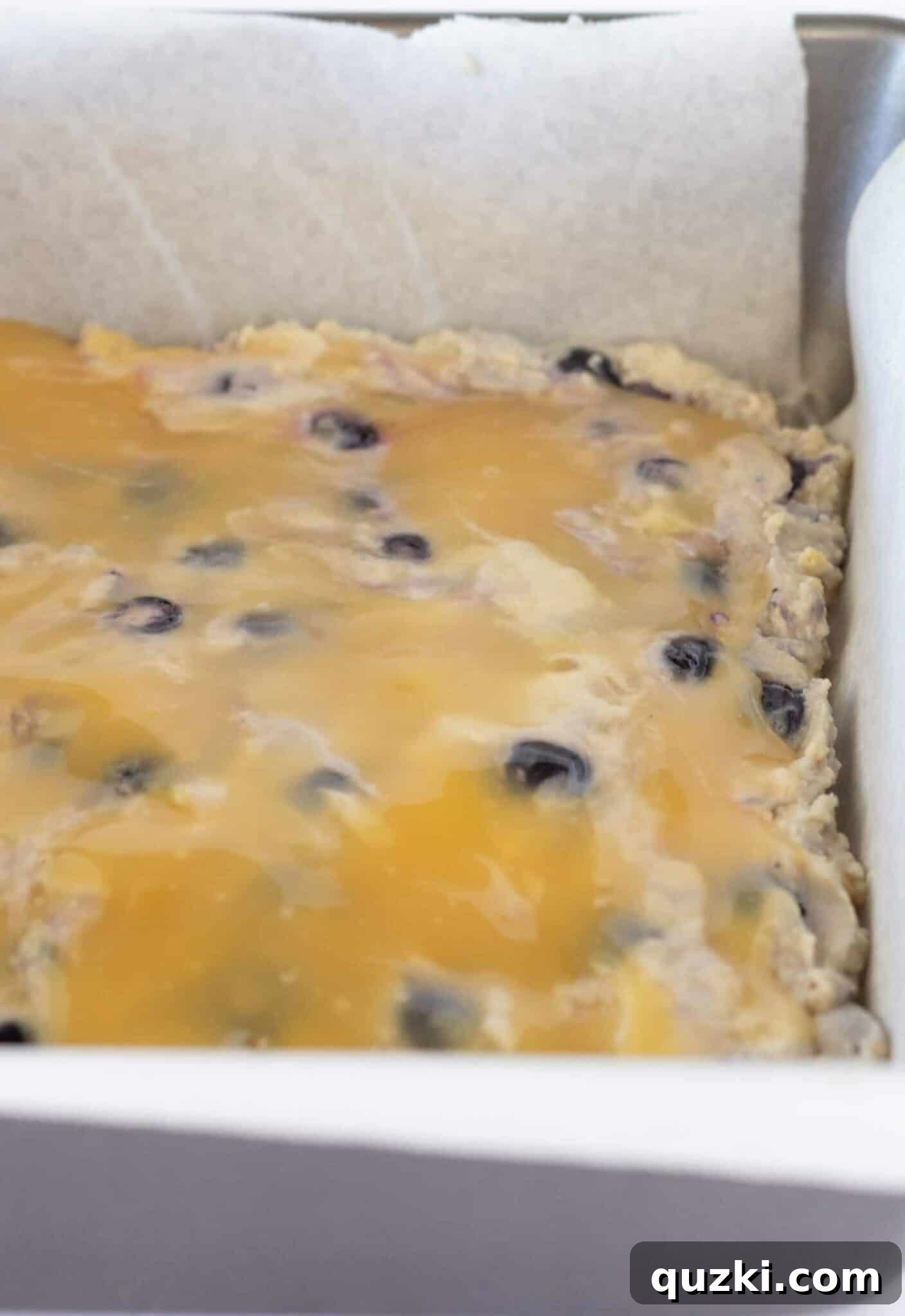 Effortless Lemon Blueberry Sour Cream Crumb Cake 9 Finishing the cake assembly by adding the remaining batter over the lemon curd, preparing for the crumb topping.