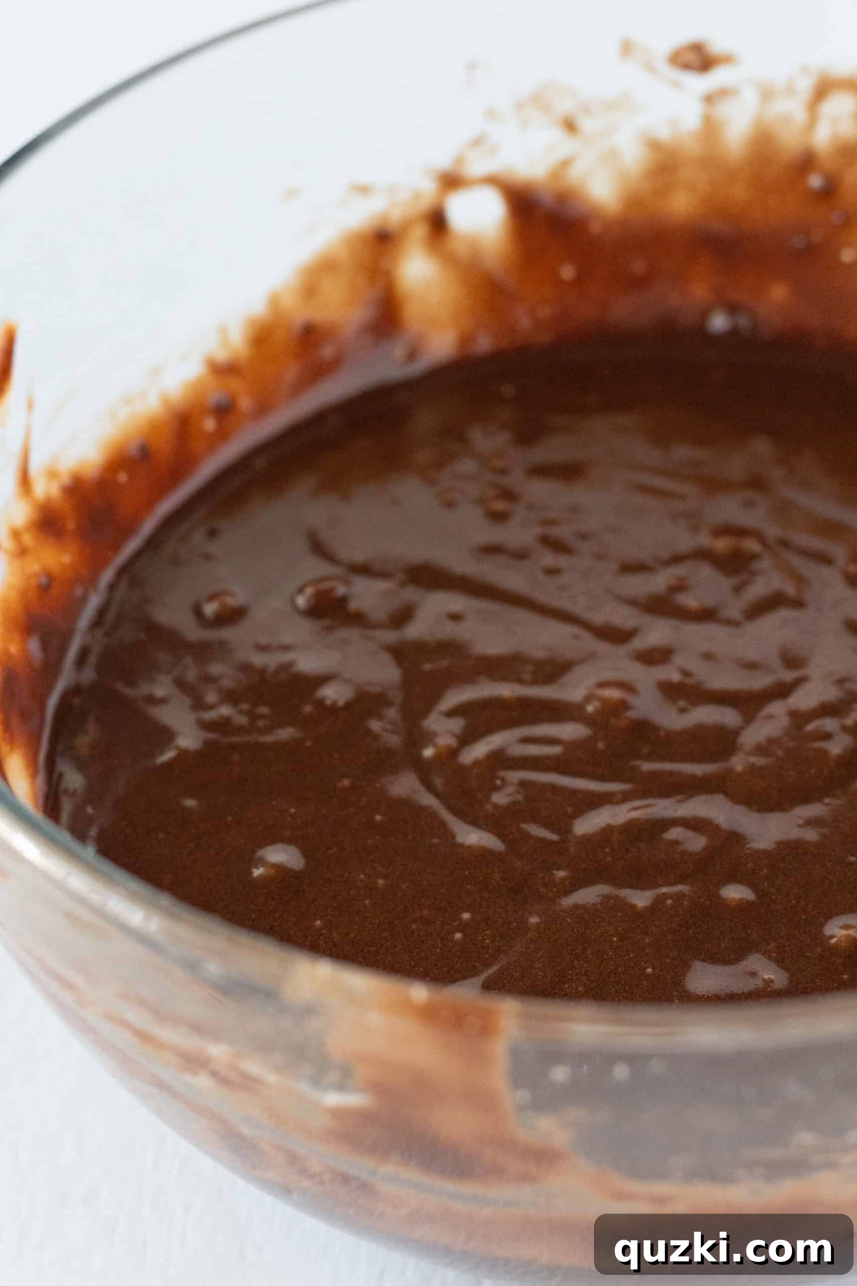 Preparing the brownie batter in a mixing bowl, showcasing the rich, dark chocolate color.