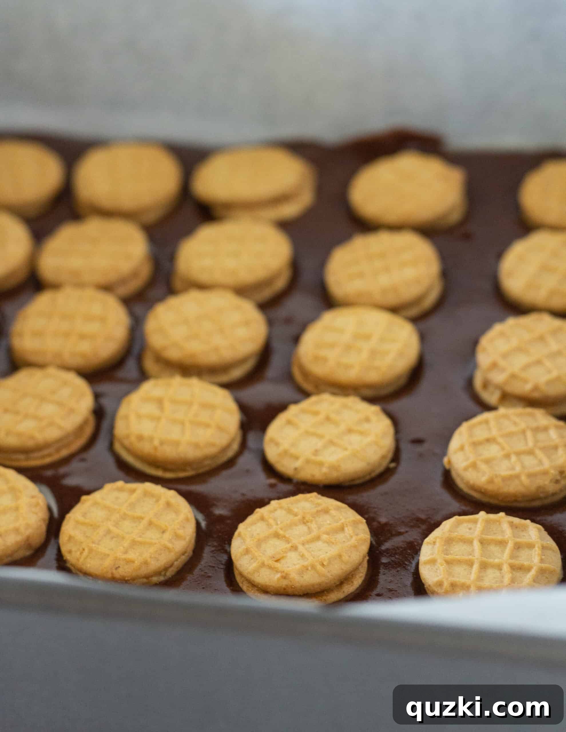 Layering the first portion of brownie batter in the pan, forming the base for the cookies.