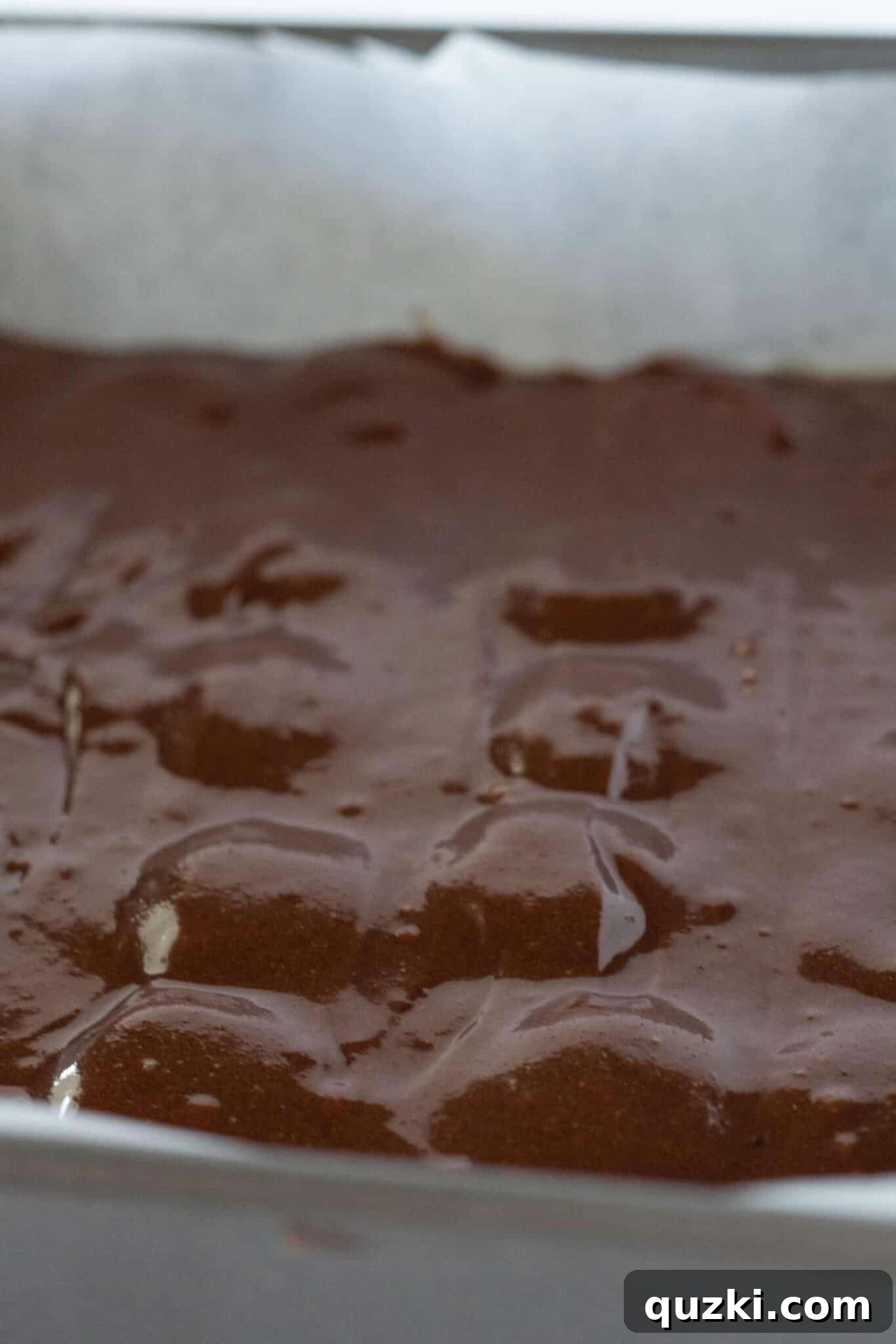 Placing mini Nutter Butter cookies onto the brownie batter layer, then covering with the remaining batter.