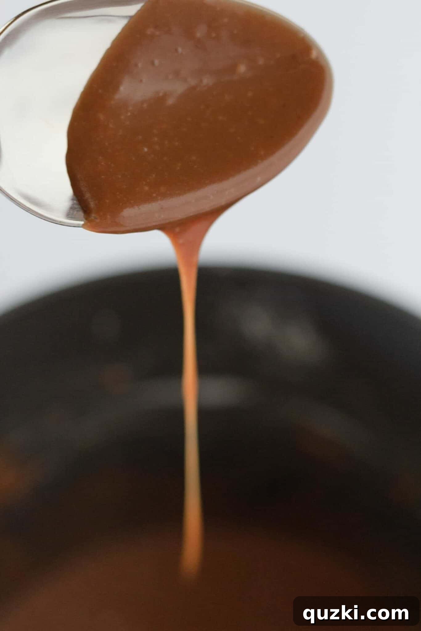 Preparing the chocolate frosting in a saucepan, showing the smooth, glossy texture.