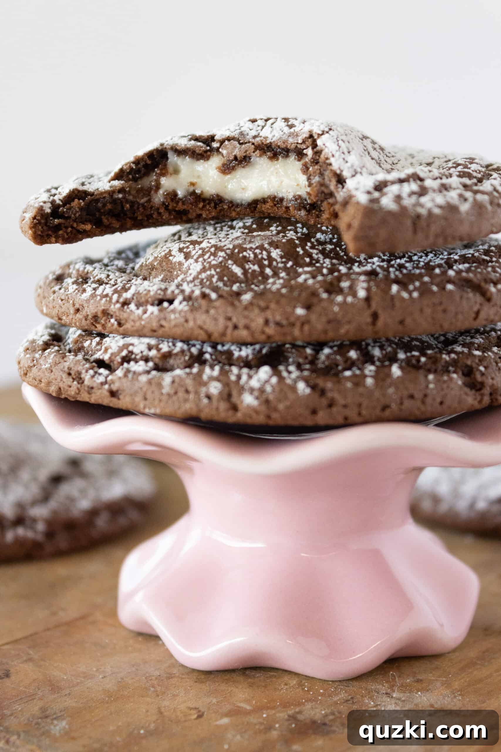 Cake Mix Chocolate Cheesecake Cookies 13 A delicious Chocolate Cheesecake Cookie cut in half, revealing the soft chocolate exterior and creamy, baked cheesecake filling.