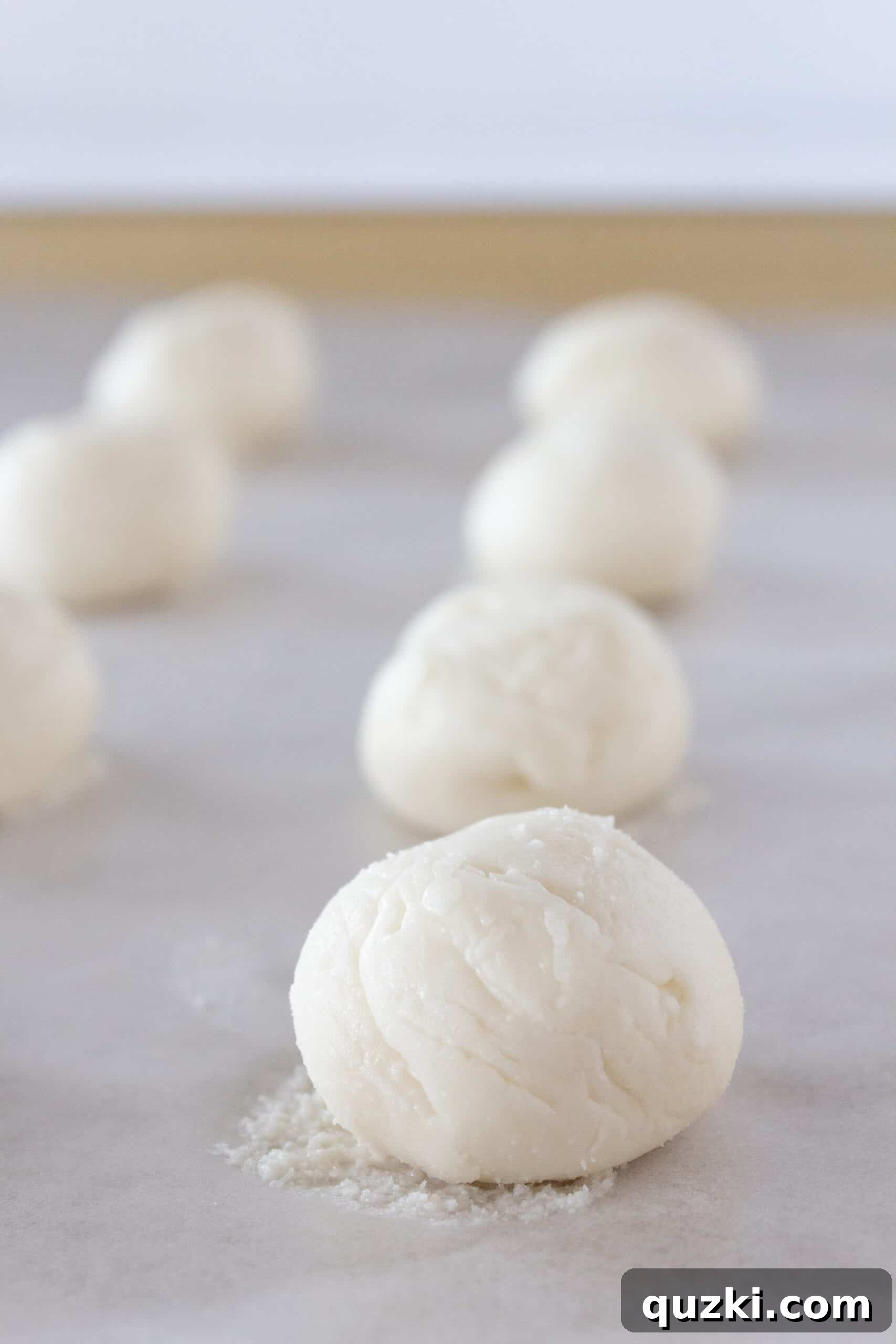 Cake Mix Chocolate Cheesecake Cookies 5 Frozen cheesecake filling balls on a parchment-lined baking sheet, ready to be stuffed into chocolate cookies.
