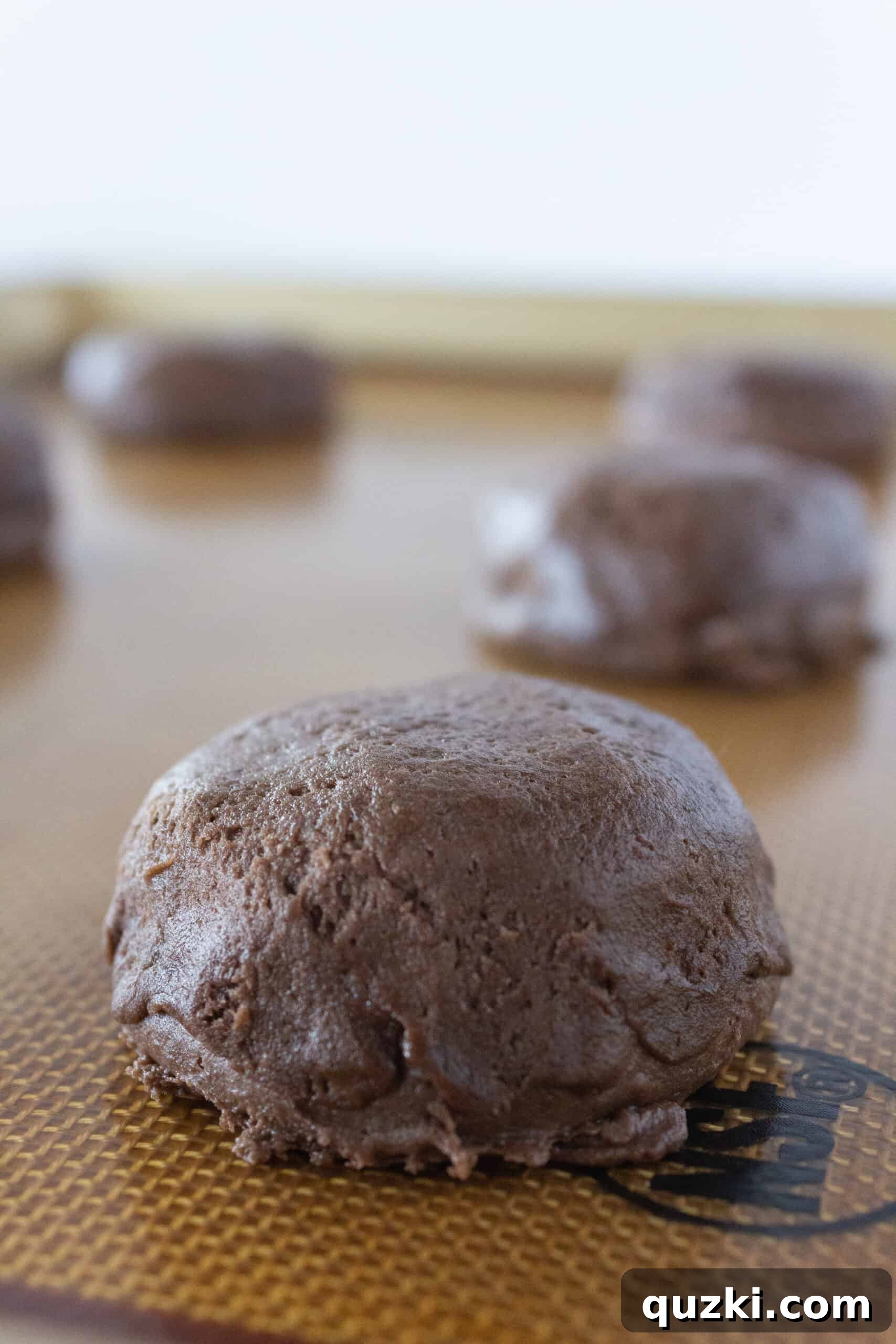 Cake Mix Chocolate Cheesecake Cookies 10 Final smoothing of the edges on a stuffed chocolate cheesecake cookie before baking, ensuring a polished appearance.