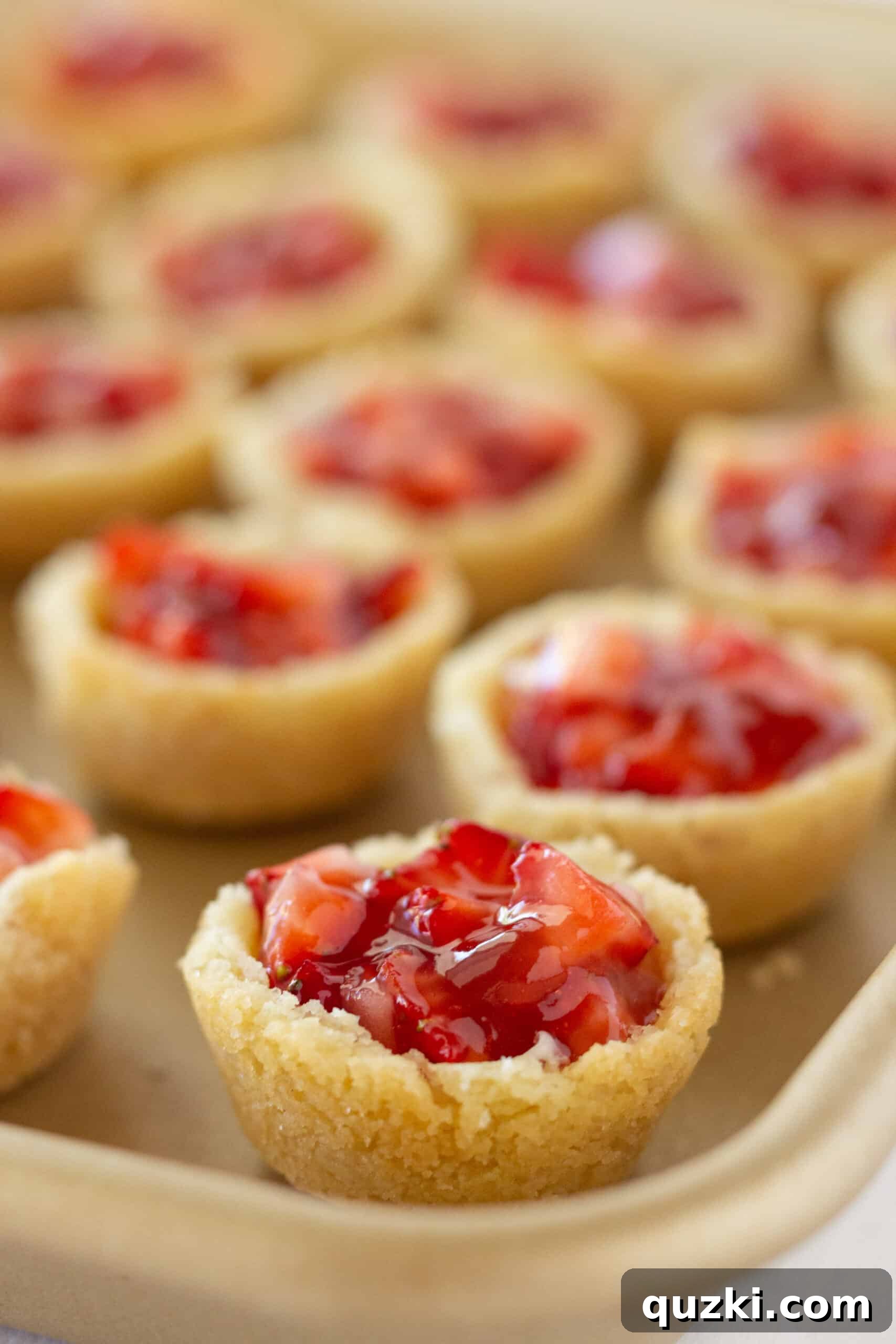 Decadent Strawberry Cream Cheese Pastries 12 The final step of spooning the strawberry topping onto the cream cheese filled pastry bites.