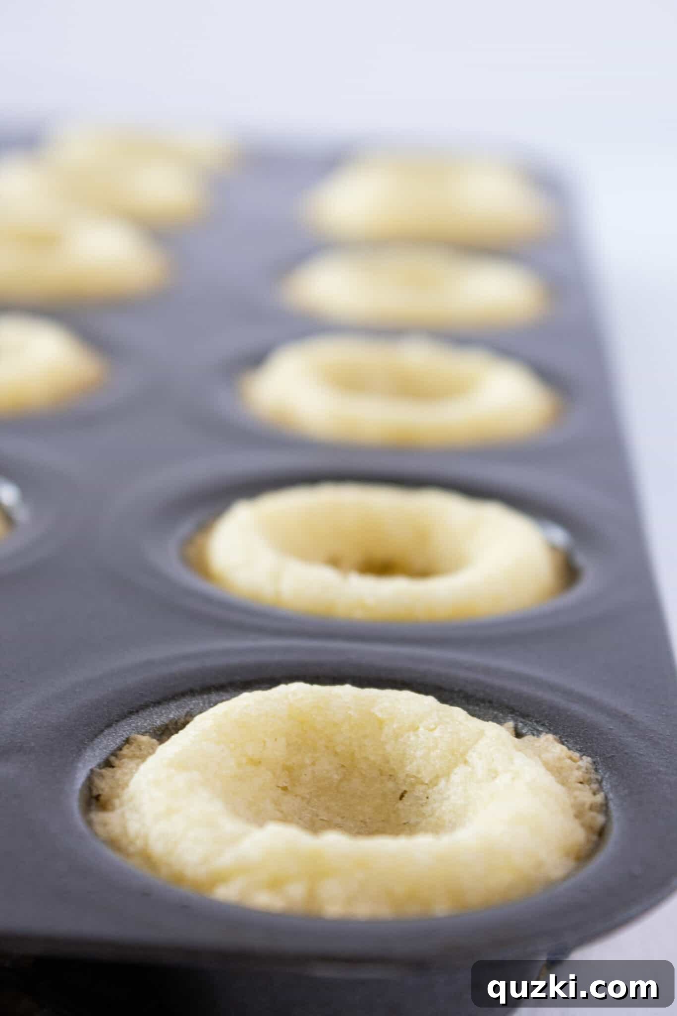 Decadent Strawberry Cream Cheese Pastries 6 Freshly baked sugar cookie cups in a mini muffin pan, showing their perfect golden edges.