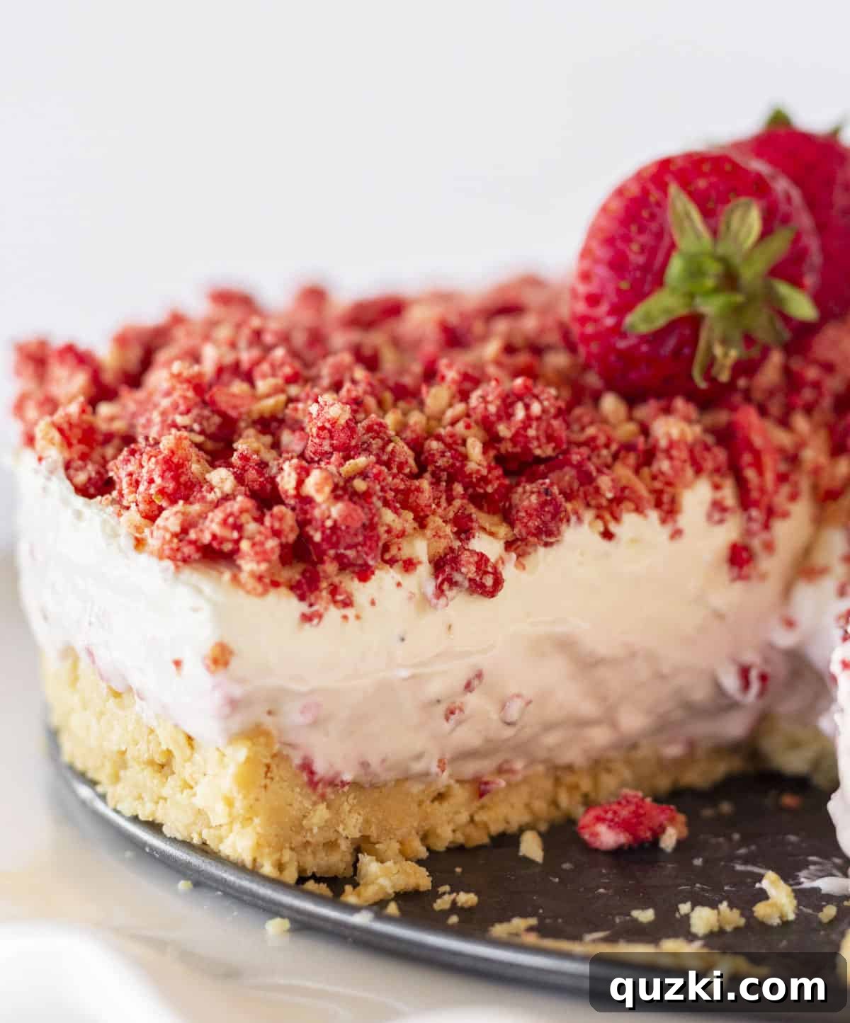 A slice of No-Bake Strawberry Crunch Cheesecake with a perfect crunch topping and fresh strawberries.