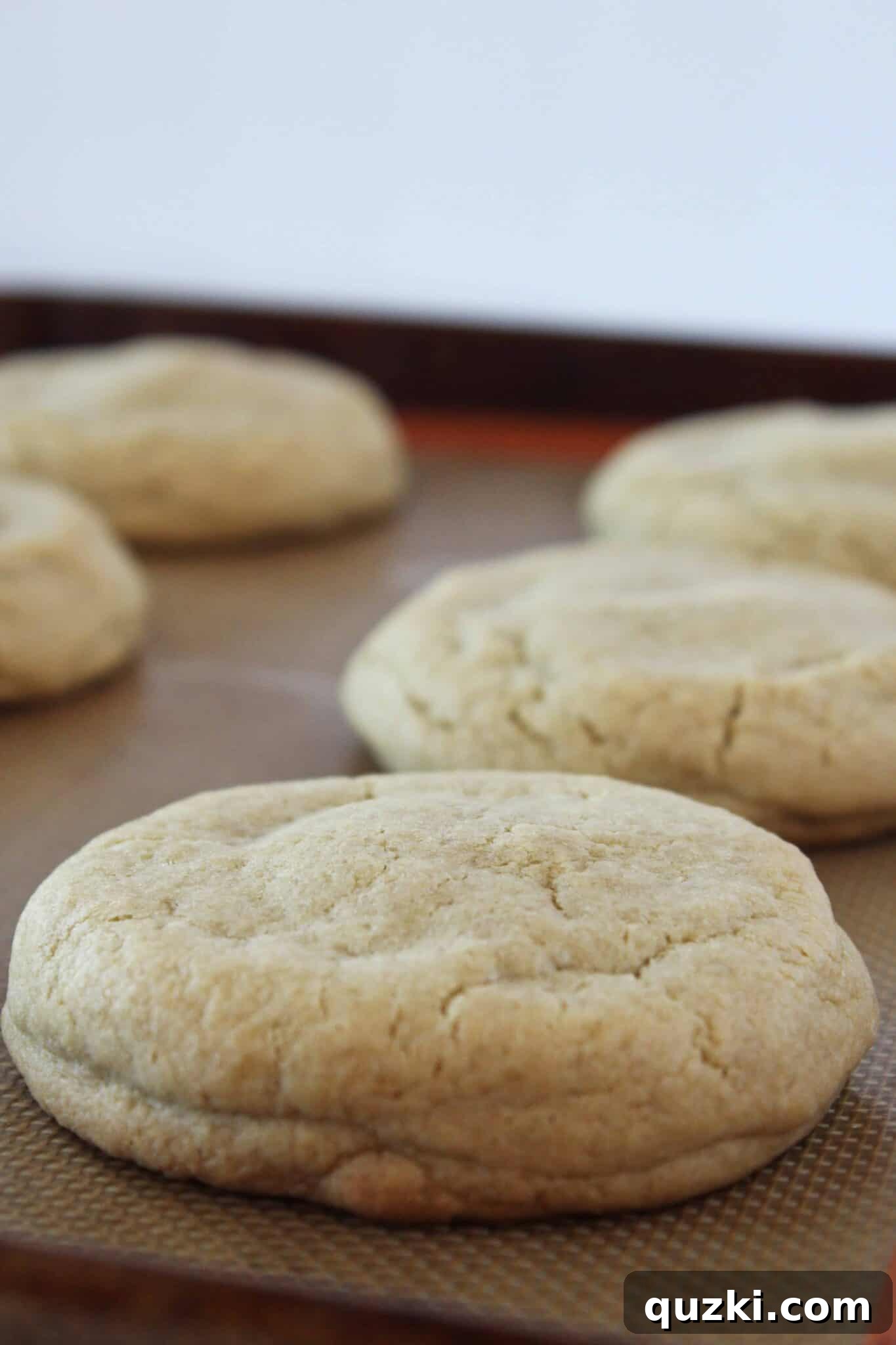 Ultimate Reese's Peanut Butter Cup Cookies 12 Freshly baked Reese's Peanut Butter Cup Stuffed Cookies cooling on a parchment-lined baking sheet