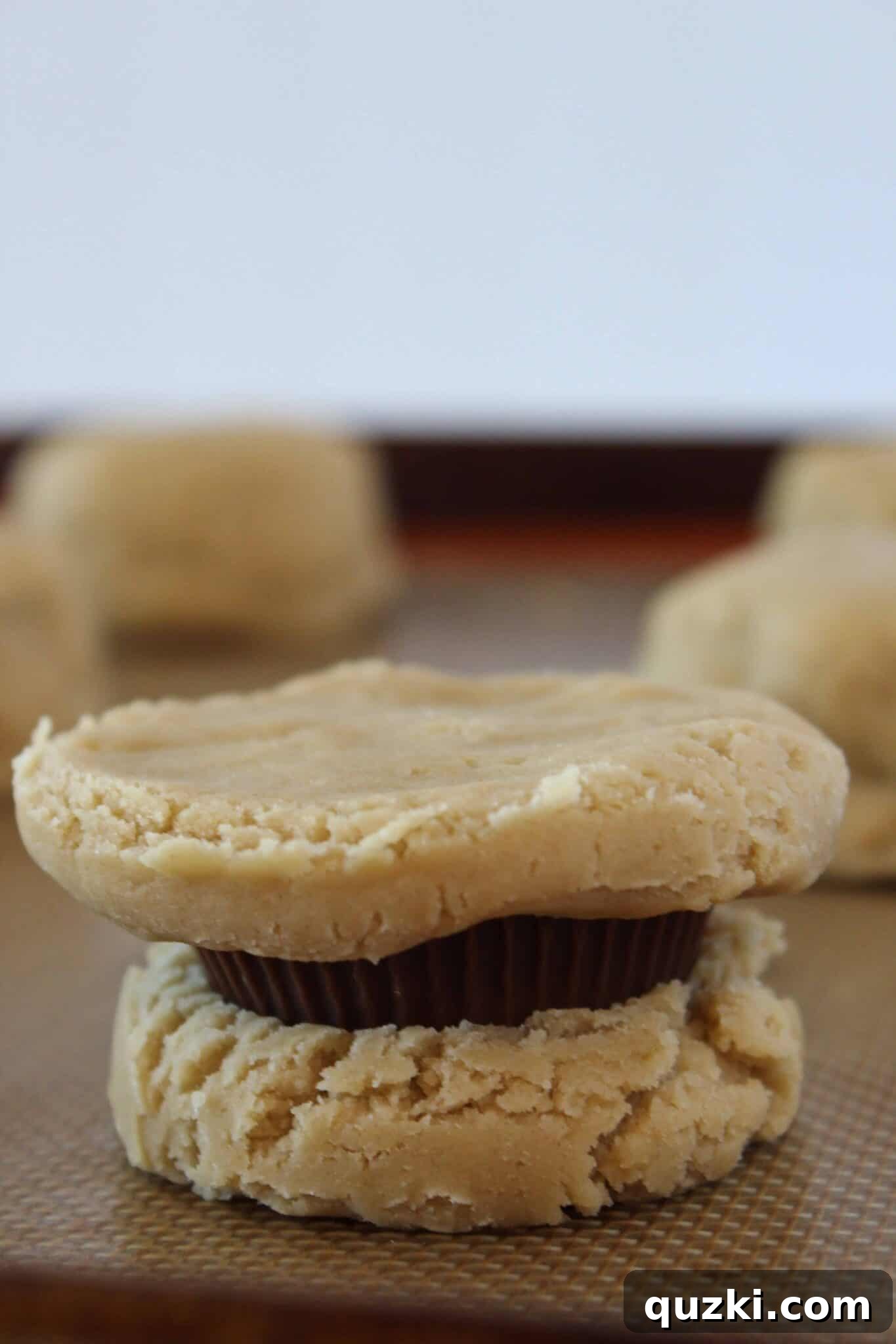 Ultimate Reese's Peanut Butter Cup Cookies 10 Cookie dough meticulously sealed around a Reese's Peanut Butter Cup, forming a perfect cookie ball