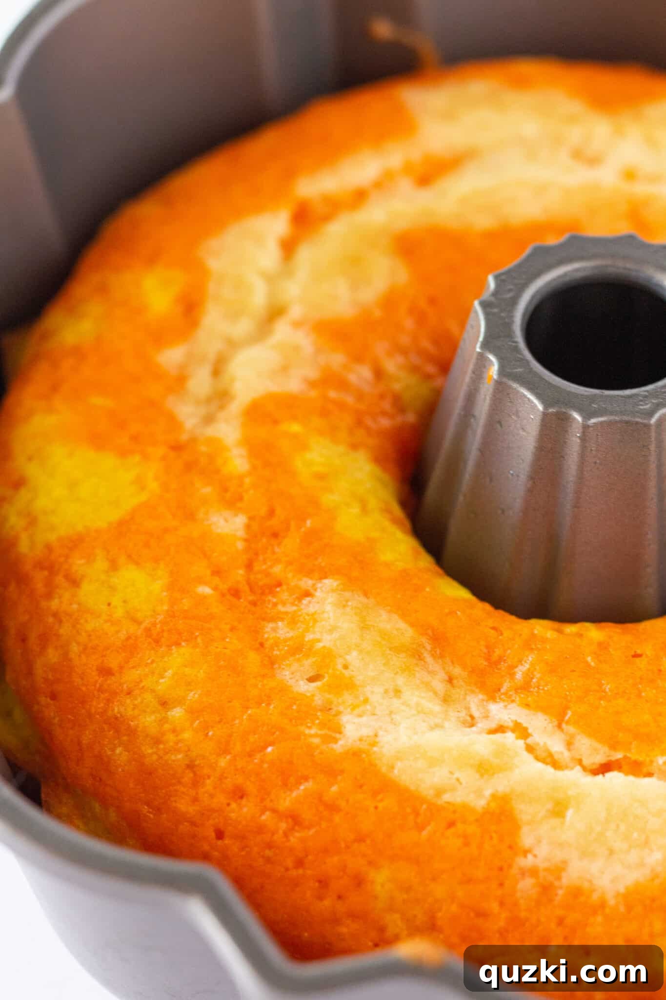 The baked Candy Corn Bundt Cake, still in its pan, showing its golden-brown top before inversion.