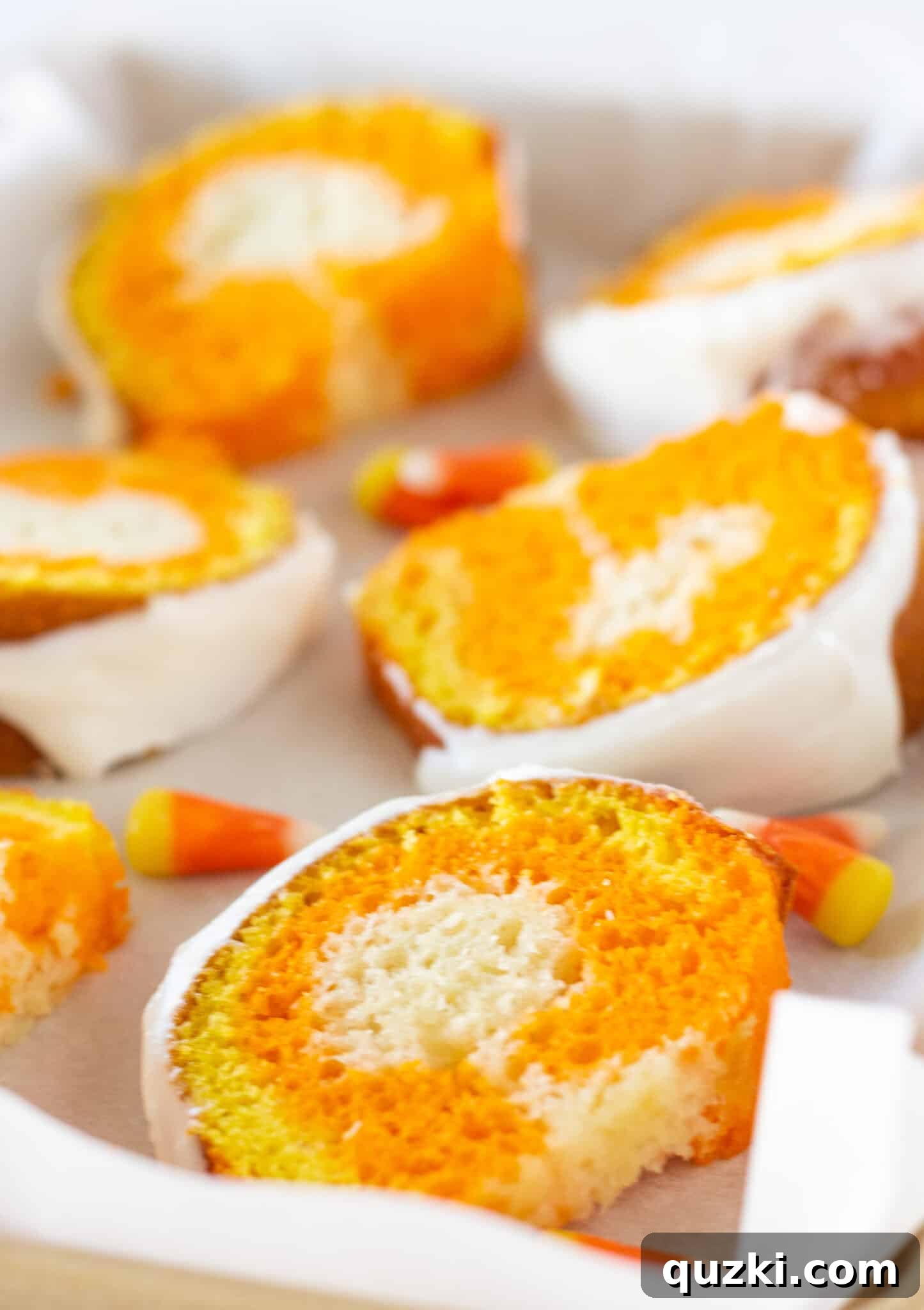Several slices of Candy Corn Bundt Cake arranged neatly on a serving tray, showcasing their colorful layers.