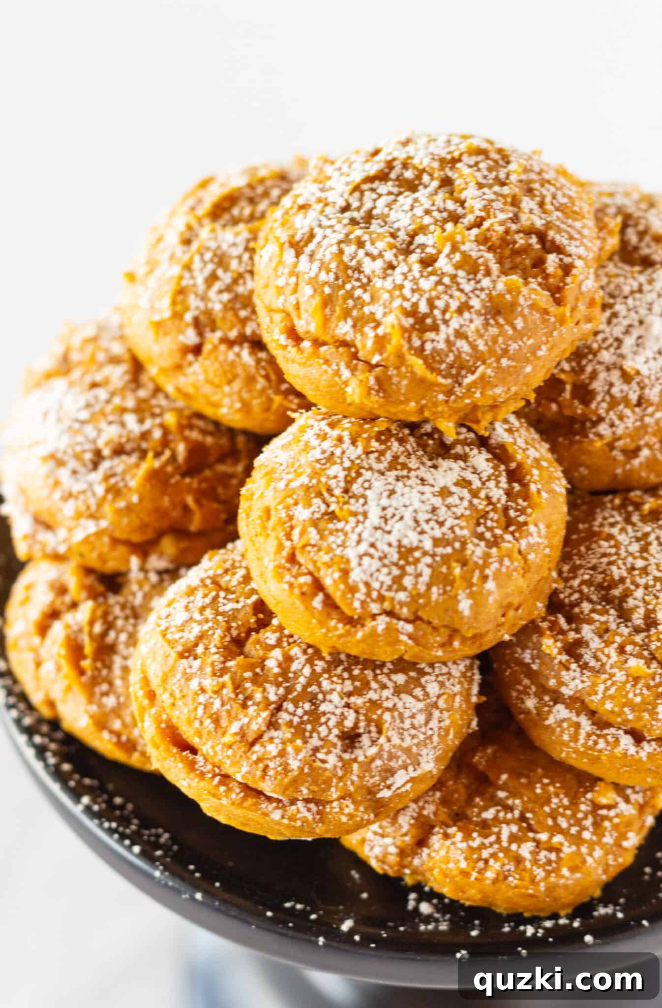 A stack of perfectly baked and frosted Pumpkin Cream Cheese Cookies, showcasing their soft texture.