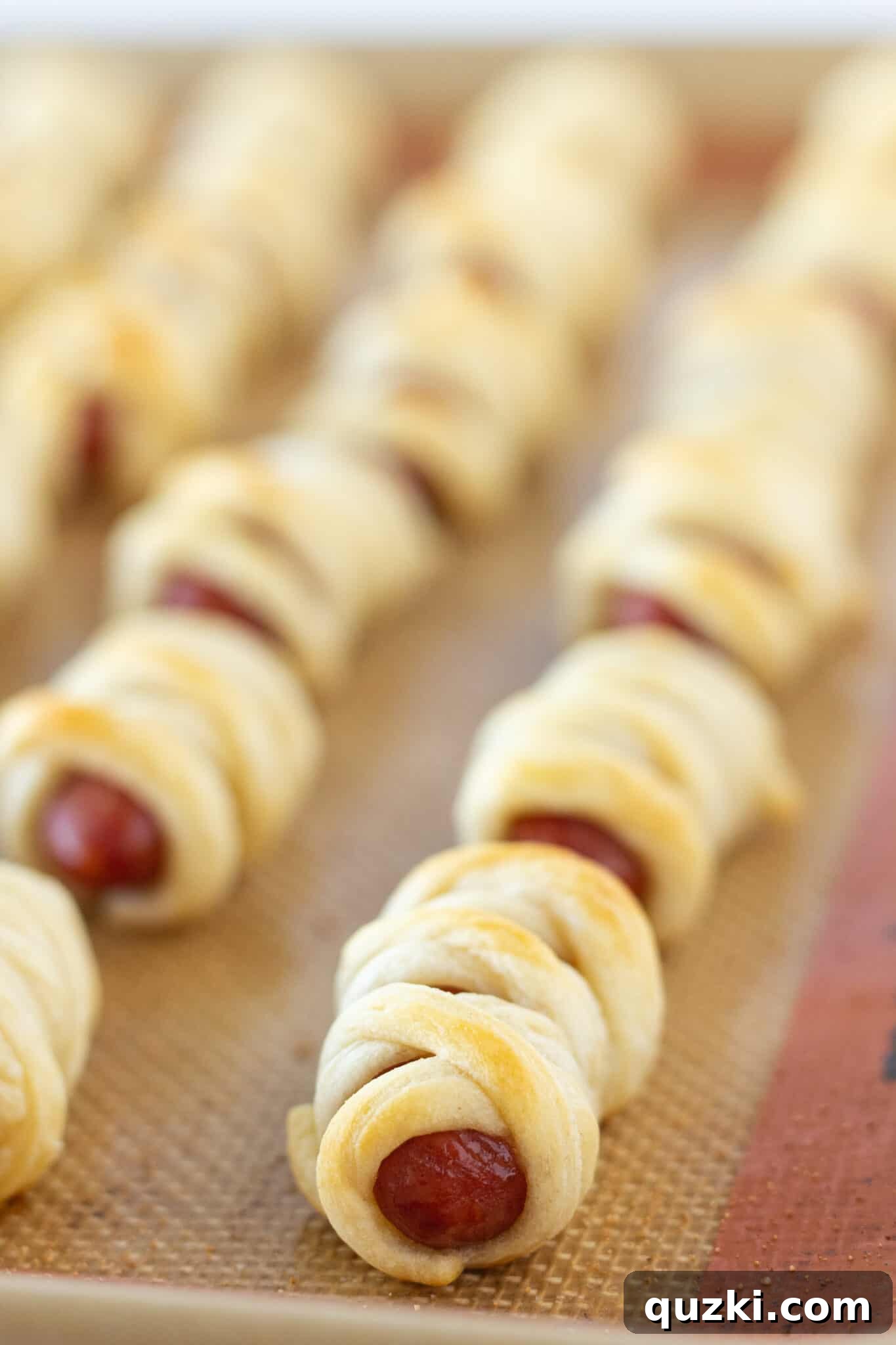 Frightfully Good Mummy Franks 5 A tray of freshly baked Mini Mummy Hot Dogs, golden and ready for Halloween celebrations.