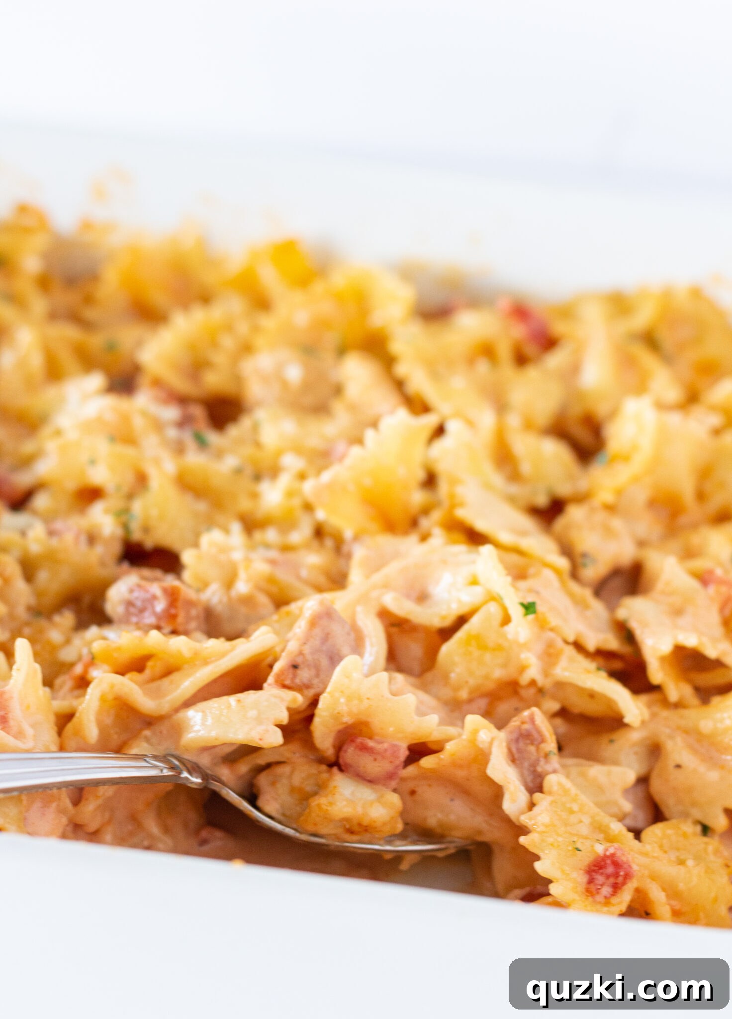 A generous scoop of Easy Cajun Chicken Pasta Casserole being served directly from the baking pan.