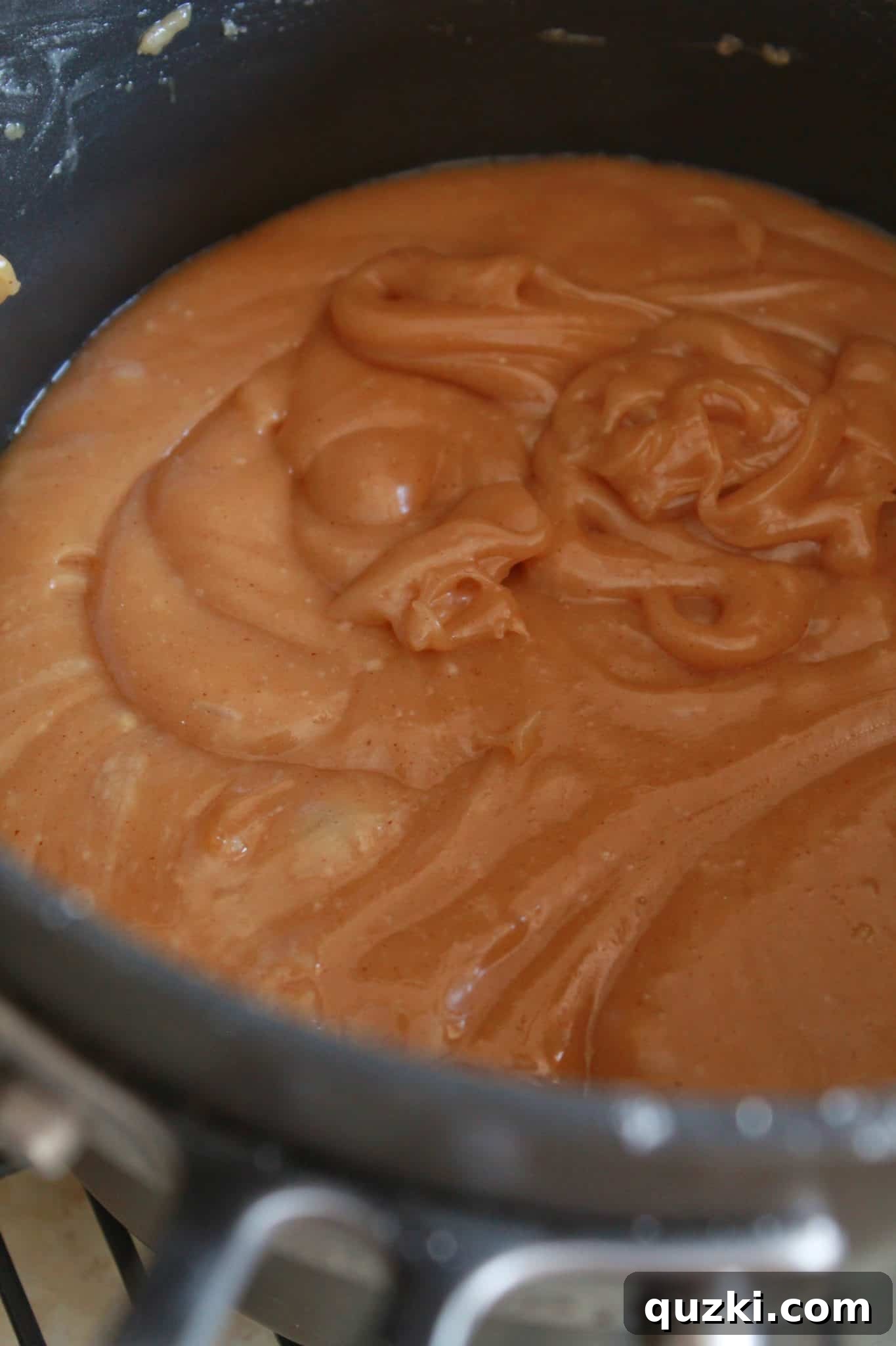 Peanut Butter Texas Sheet Cake Bundt Cake Recipe Made with a Cake Mix by top US dessert blogger, Practically Homemade - The process of preparing the creamy peanut butter frosting in a saucepan.