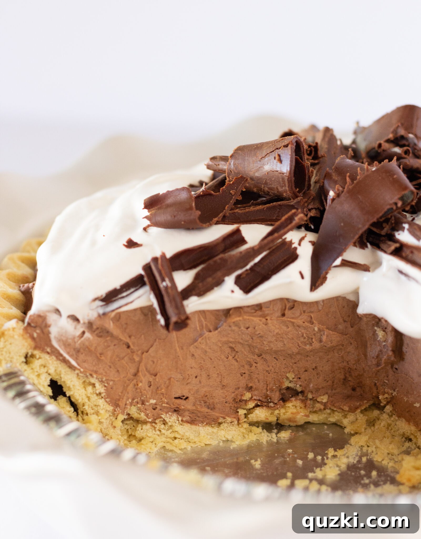 Delicious individual slice of Easy Chocolate Mousse Pie, garnished with whipped topping and chocolate curls