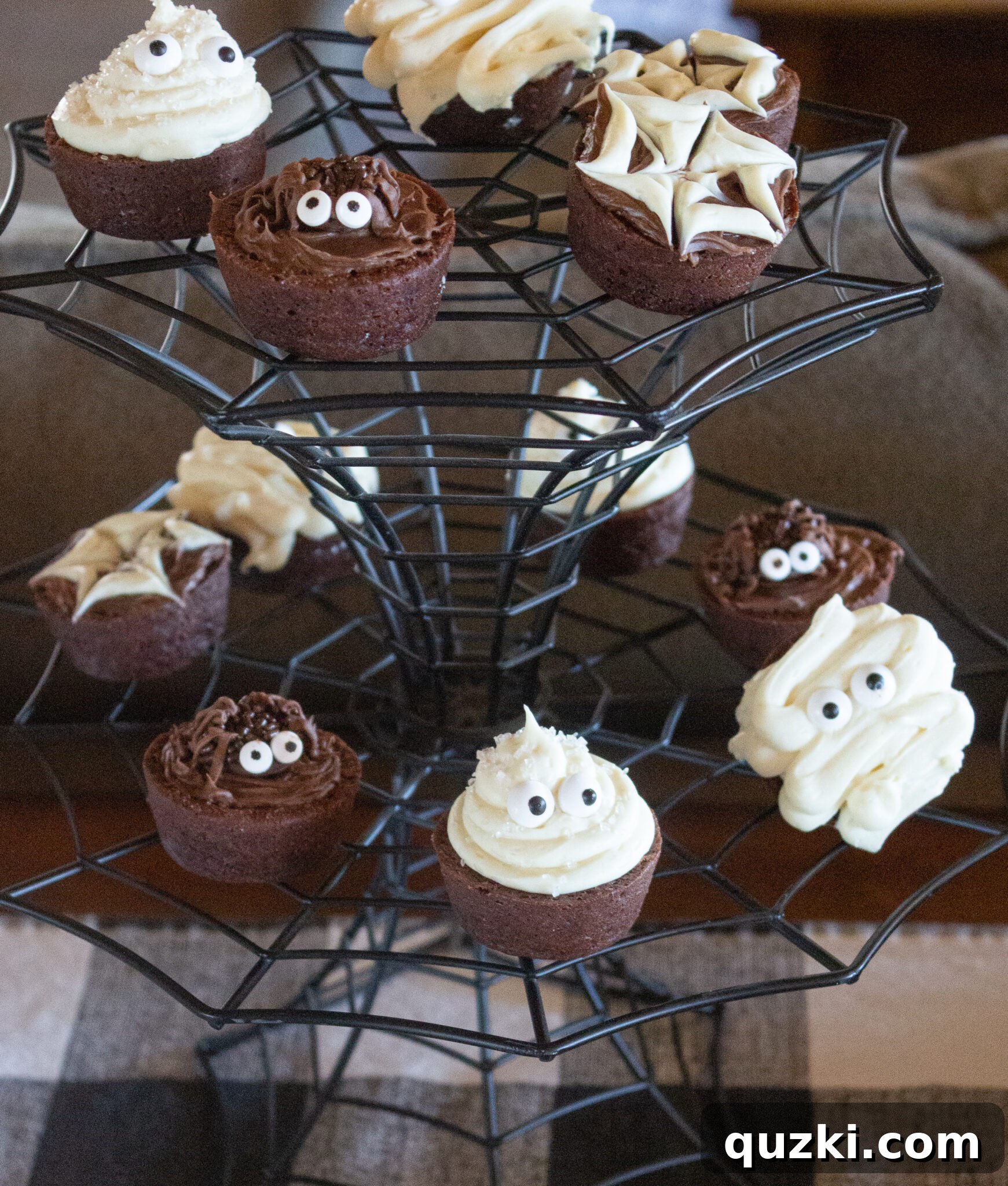 Spooktacular Halloween Dessert Display: 15 Creative and Creepy Treats 5 A spider web cake plate elegantly holding a stack of delightful Halloween brownie bites, serving as a focal point.