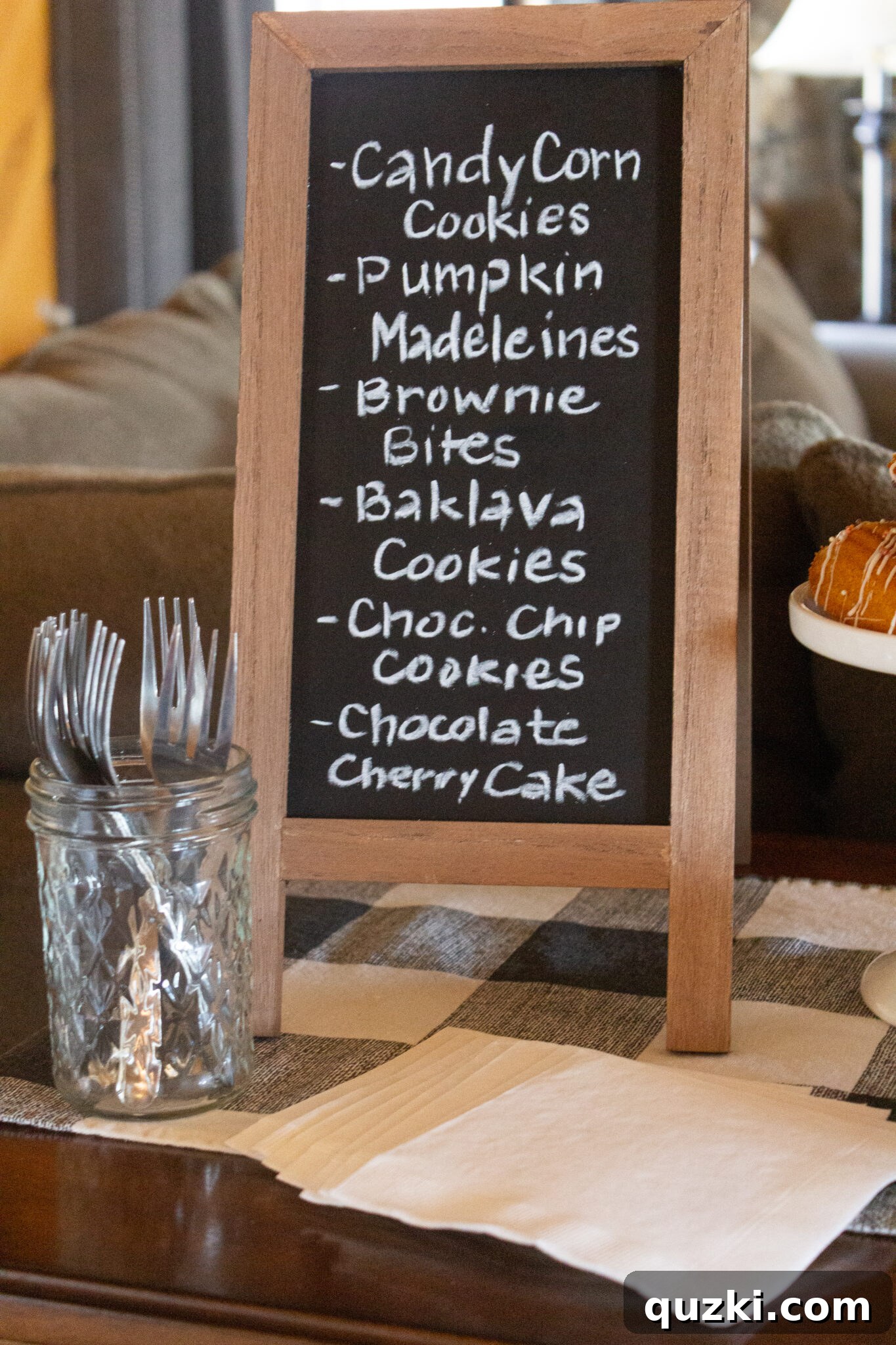 Spooktacular Halloween Dessert Display: 15 Creative and Creepy Treats 6 A Halloween Dessert Table with a prominent chalkboard displaying a list of all the treats available on the table.