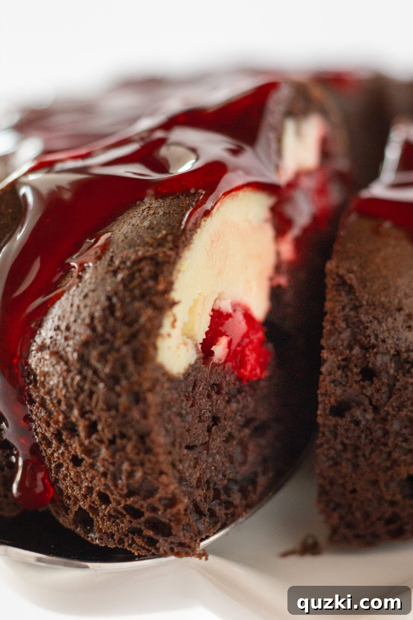 Close-up of a slice of Cherry Cheesecake Chocolate Bundt Cake, showcasing the rich chocolate cake and creamy cherry cheesecake swirl.