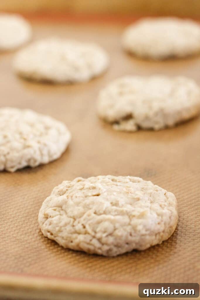Freshly baked cake mix oatmeal cookies cooling on a sheet tray after being removed from the oven.