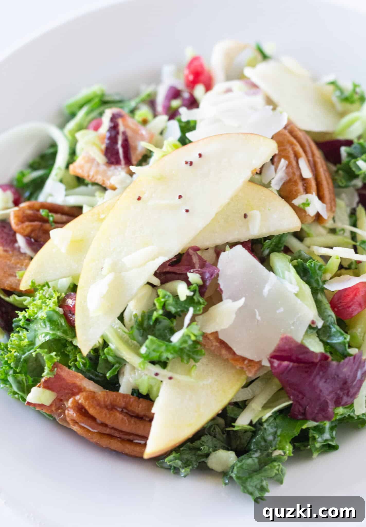 Crisp Autumn Apple Salad 3 A generous serving of Harvest Salad with Apples, bacon, and pomegranate seeds in a white bowl, ready to be enjoyed.