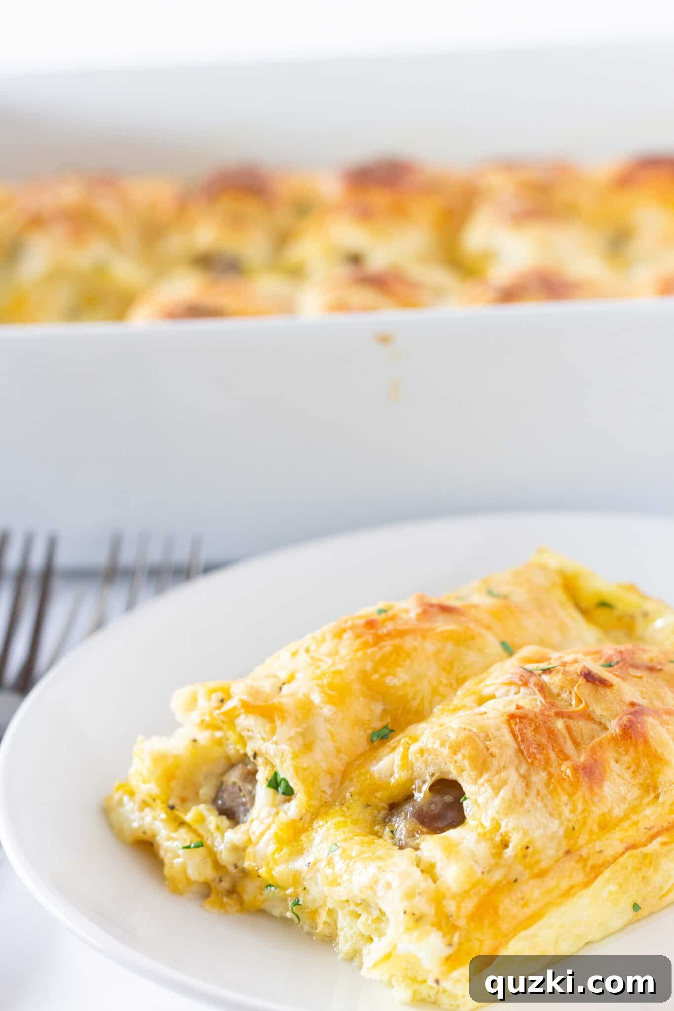 Ultimate Pigs in a Blanket Breakfast Casserole 3 Pigs in a Blanket Breakfast Casserole served in a large 9x13 baking dish, showcasing individual crescent-wrapped sausages.