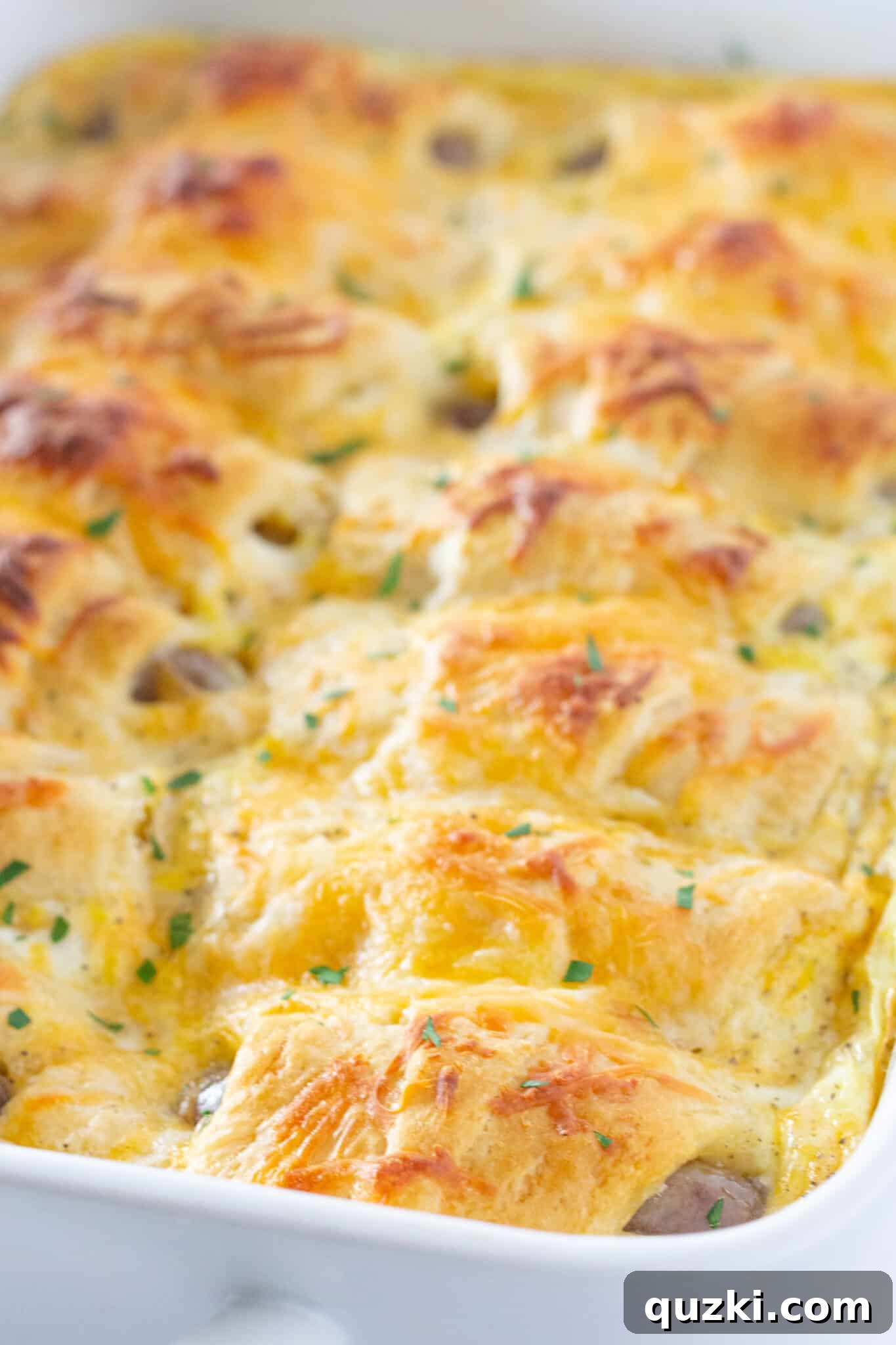 Ultimate Pigs in a Blanket Breakfast Casserole 5 Close-up of the delicious Pigs in a Blanket Breakfast Casserole, showcasing the fluffy eggs and golden crescent rolls, a recipe featured by Practically Homemade.