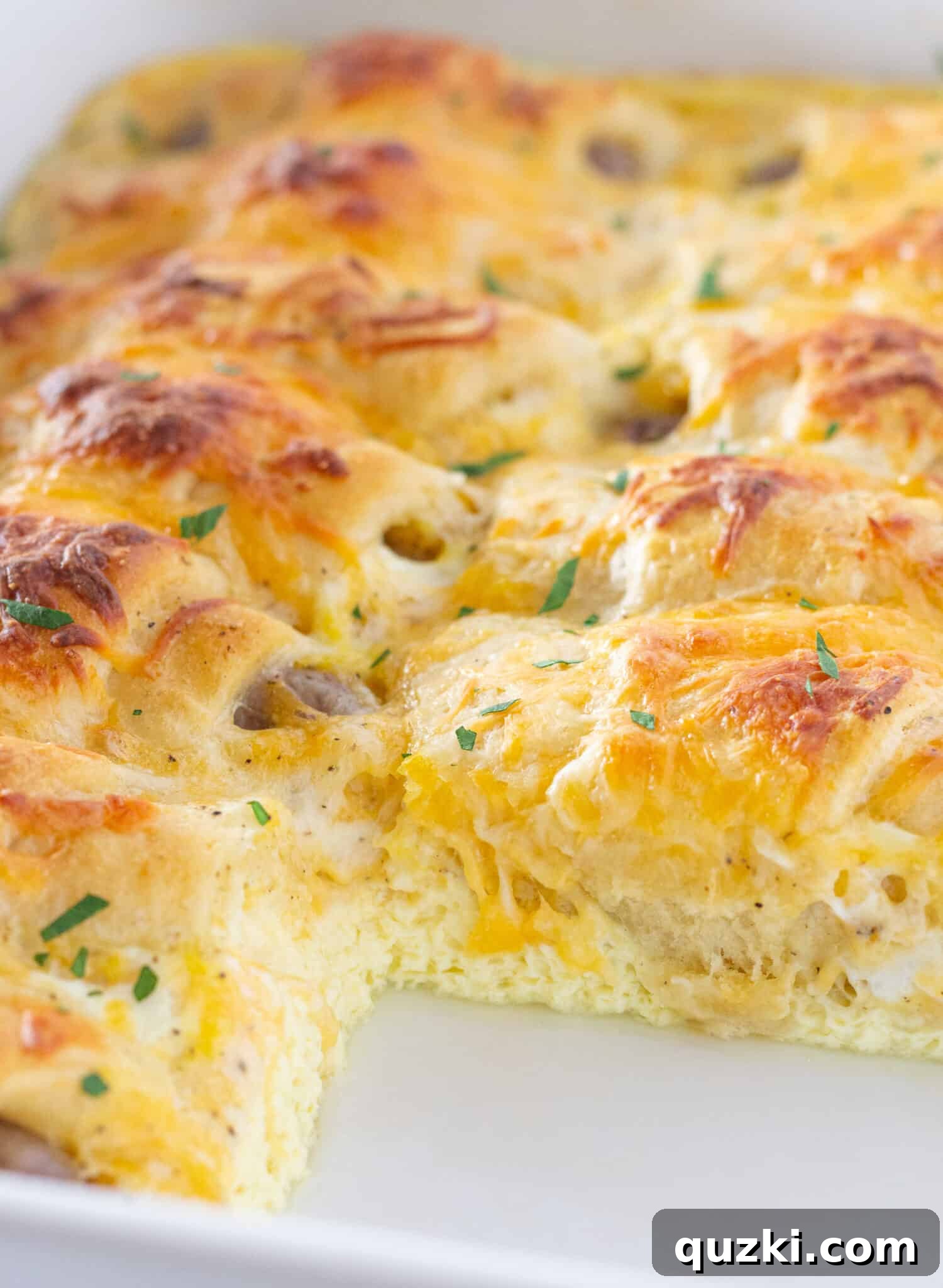 Ultimate Pigs in a Blanket Breakfast Casserole 6 A serving of Pigs in a Blanket Breakfast Casserole on a plate, ready to be enjoyed with a fork.