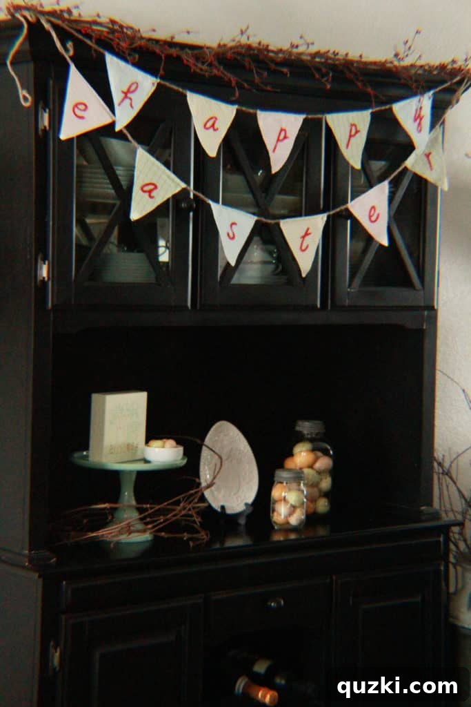 Hop into Easter Decor Ideas 11 Easter decorations on a home hutch, featuring a cheerful 'Happy Easter' banner, a collection of white decorative pieces, and an assortment of charming Easter eggs, creating a festive focal point in a small space.