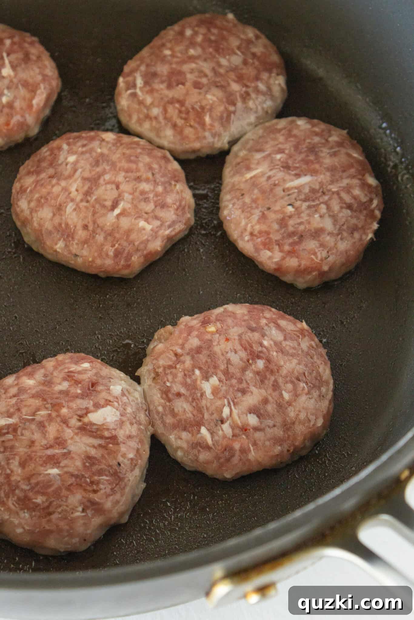 Sweet and Savory Pancake Sausage Egg Sliders 7 Sausage patties cooking in a skillet, ready to be added to the breakfast sliders