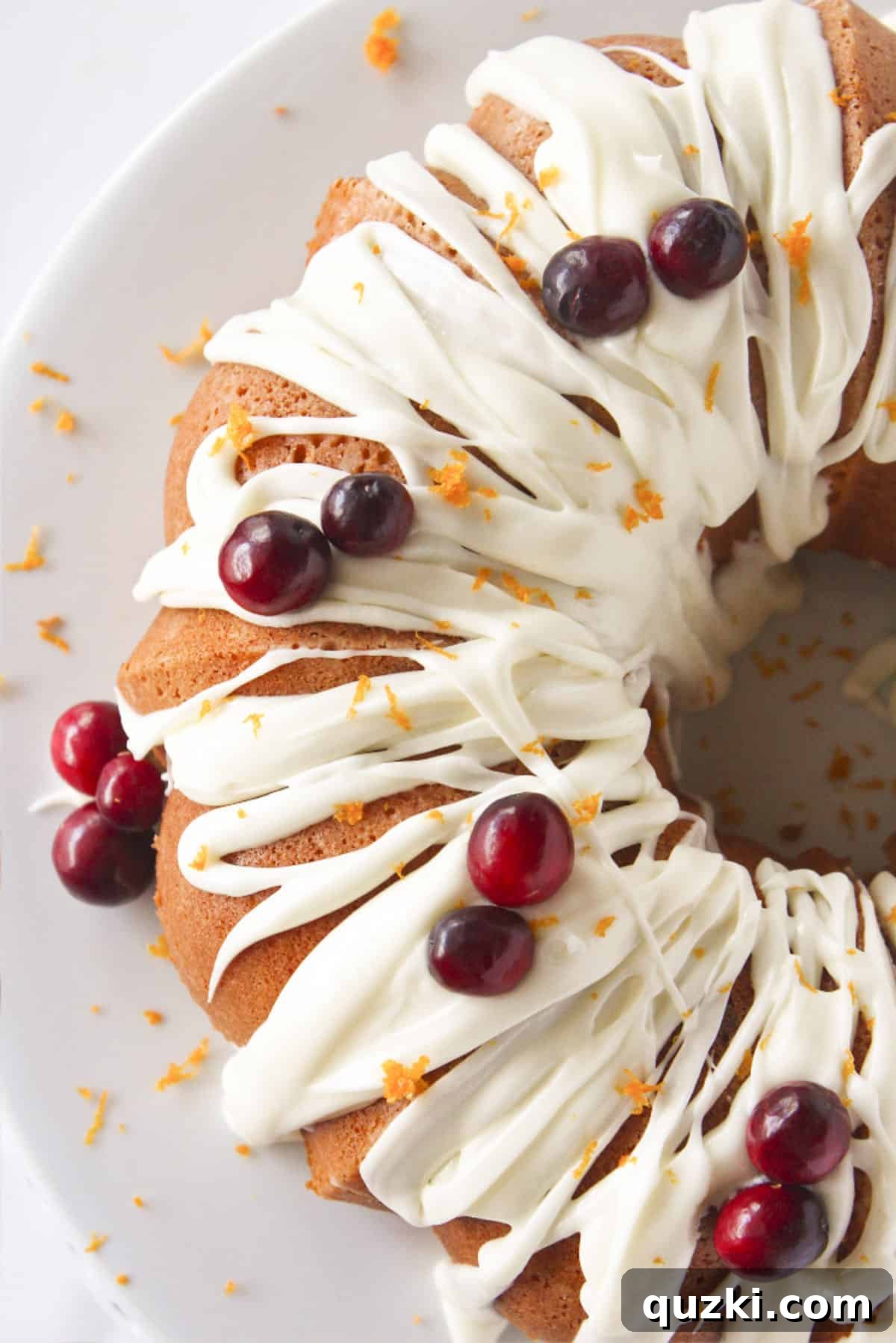 Stunning Christmas Bundt Cakes to Dazzle Your Guests 16 A delicious Cranberry Orange Bundt Cake, adorned with fresh cranberries and delicate orange zest, ready to be sliced.
