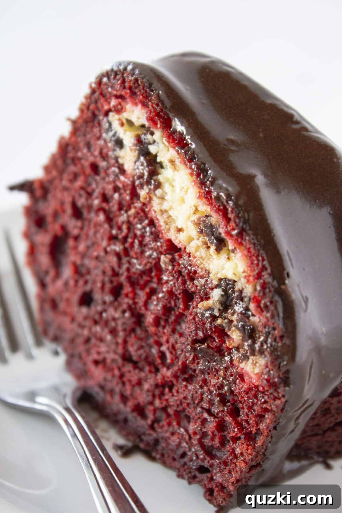 Stunning Christmas Bundt Cakes to Dazzle Your Guests 7 A perfect slice of Red Velvet Black Bottom Cake, highlighting the contrasting layers of red velvet cake and creamy white filling.