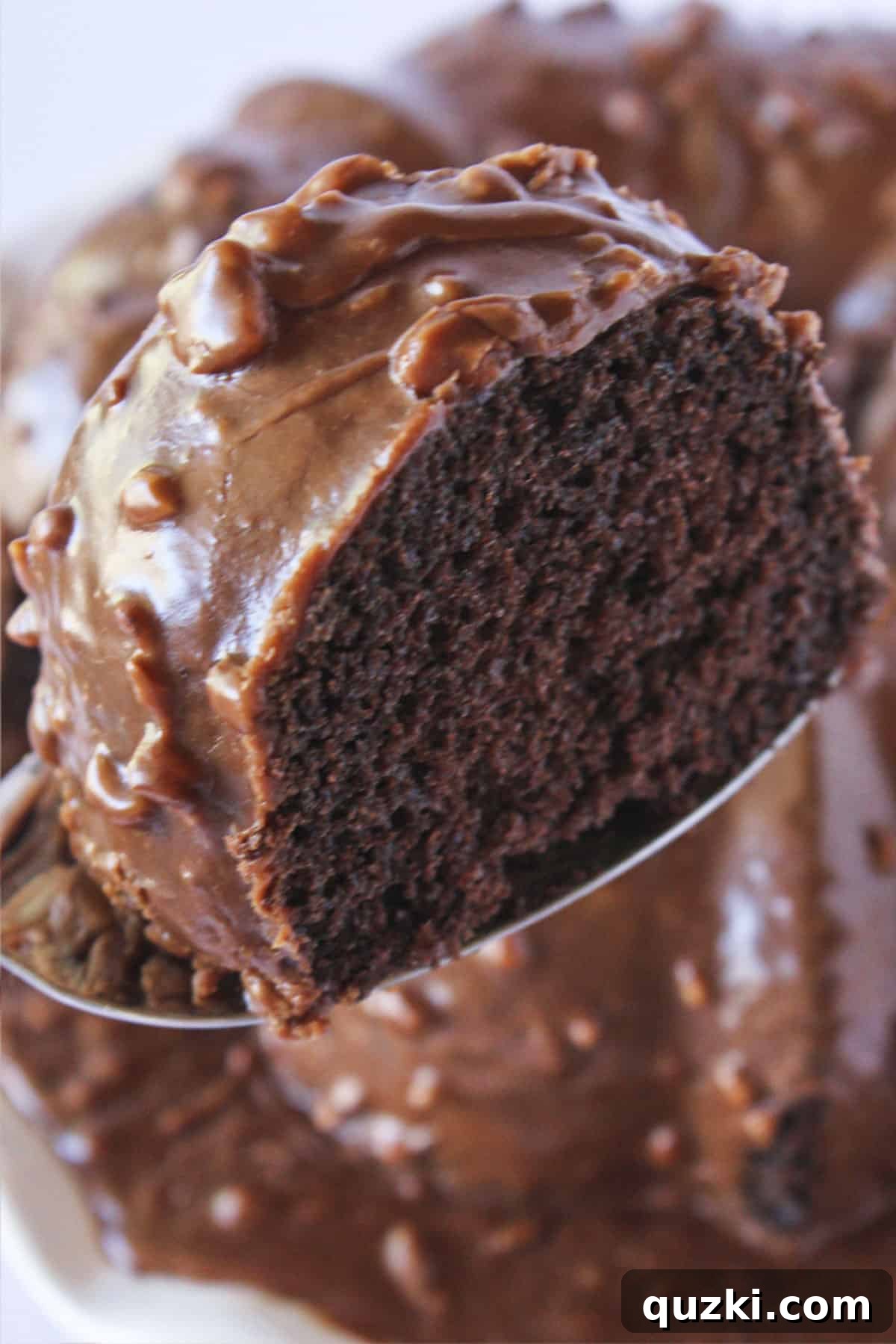 Stunning Christmas Bundt Cakes to Dazzle Your Guests 8 A generous slice of Texas Sheet Cake Bundt Cake being served, revealing its rich chocolate interior and glossy pecan frosting.