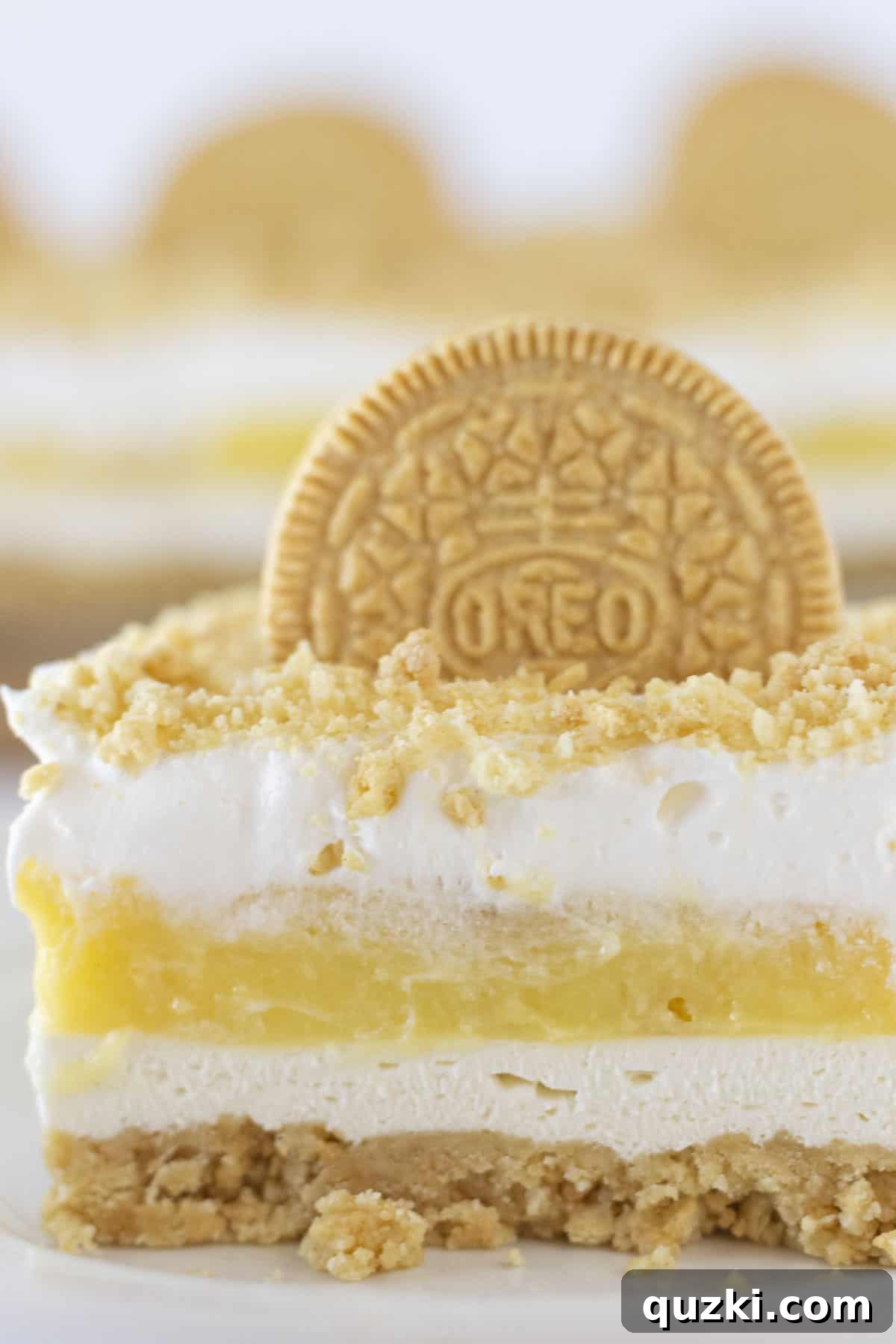 A captivating Golden Oreo Lasagna showcasing its distinct layers of crushed Golden Oreos, creamy cheesecake filling, smooth pudding, and light whipped cream, creating an irresistible dessert.