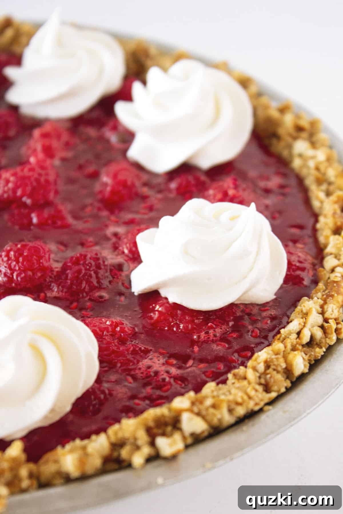 A festive No-Bake Raspberry Pretzel Pie with a crunchy pretzel crust, a creamy cheesecake layer, and a vibrant raspberry topping, ideal for holiday gatherings.