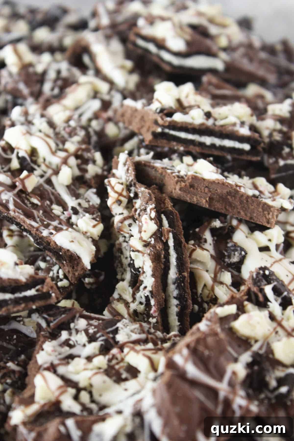 A festive tray of No-Bake Peppermint Oreo Bark, featuring a beautiful swirl of white and milk chocolate, studded with crushed peppermint candy and Oreo pieces.