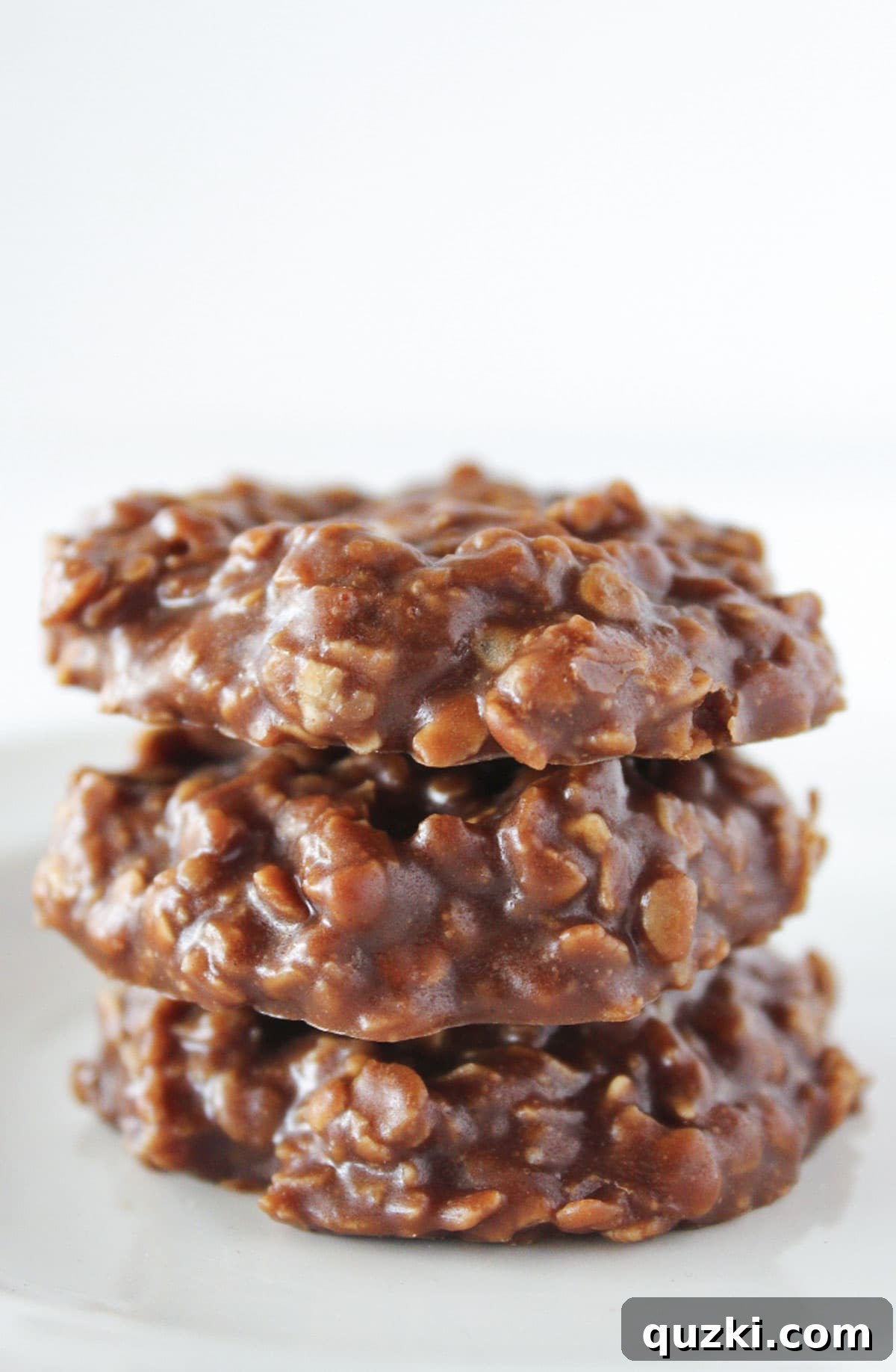 Three perfectly stacked Classic No-Bake Cookies, showcasing their iconic chocolate, peanut butter, and oat texture, ready to be enjoyed as a timeless holiday treat.