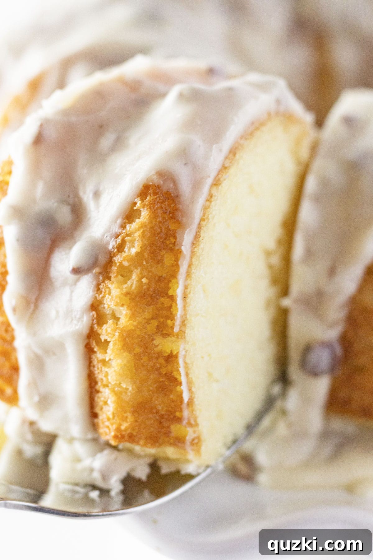 White Texas Sheet Bundt Cake Recipe 2 Serving a slice of white sheet cake bundt cake, showing its moist texture and rich pecan glaze.