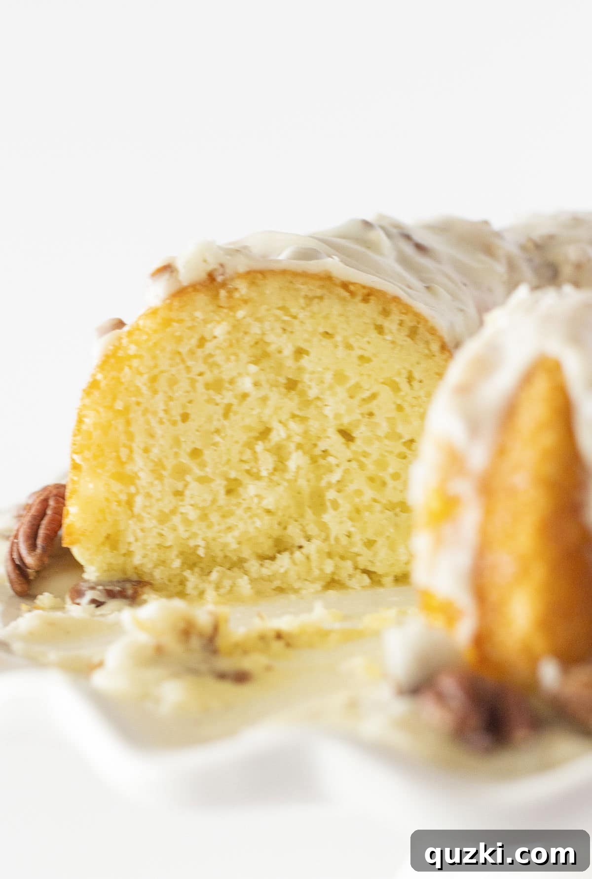 White Texas Sheet Bundt Cake Recipe 5 Looking at the inside of white sheet cake with pecan frosting after a slice is removed, highlighting its moist interior.