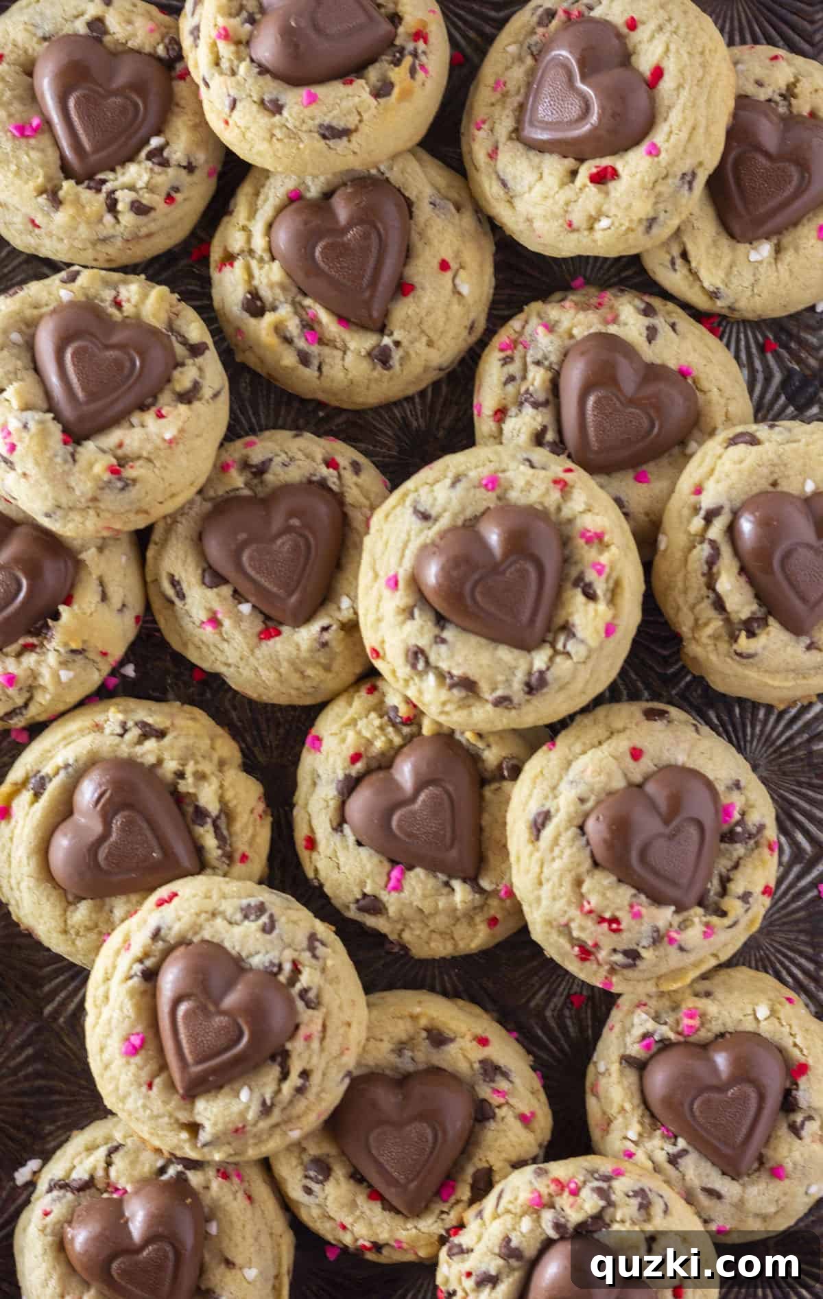 Sweetheart Chocolate Chip Cookies 2 Tray full of Valentine's Day Chocolate Chip Cookies adorned with heart sprinkles and a heart-shaped chocolate in the middle.