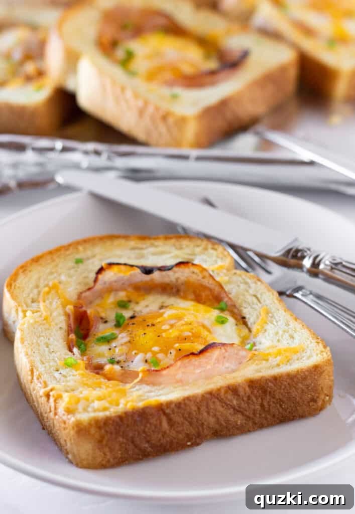 Perfectly baked Sheet Pan Ham and Eggs in a Hole, golden brown bread, melted cheese, and a perfectly cooked egg yolk, featured by Practically Homemade