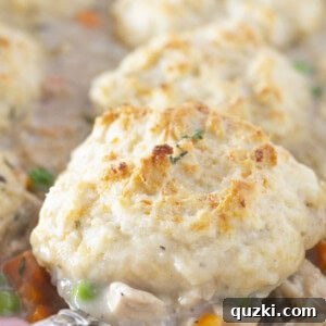 Serving chicken and biscuits casserole with a spoon.