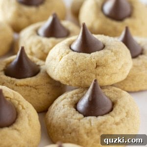 A tray of delectable peanut butter blossom cookies made with a cake mix, showcasing their golden hue and chocolate centers.
