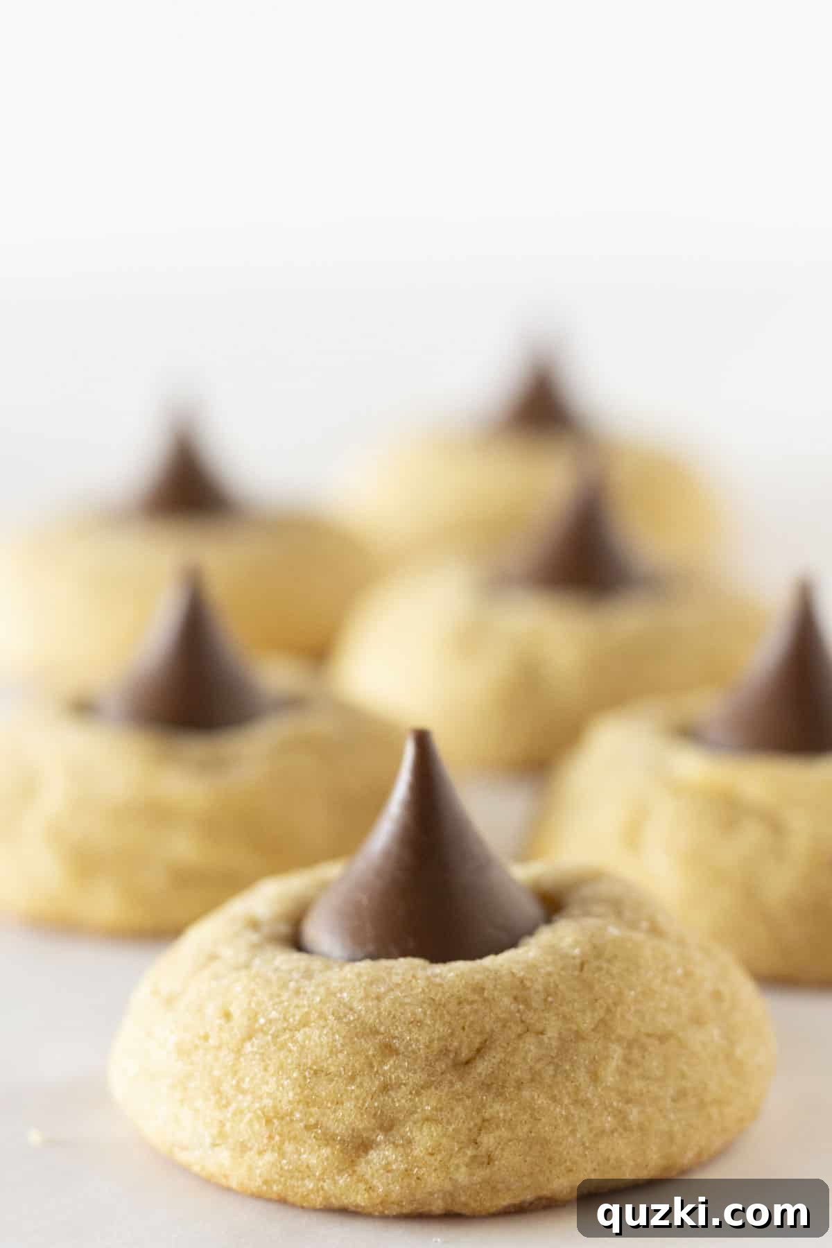 Six perfectly baked cake mix peanut butter cookies with chocolate kisses, arranged attractively.